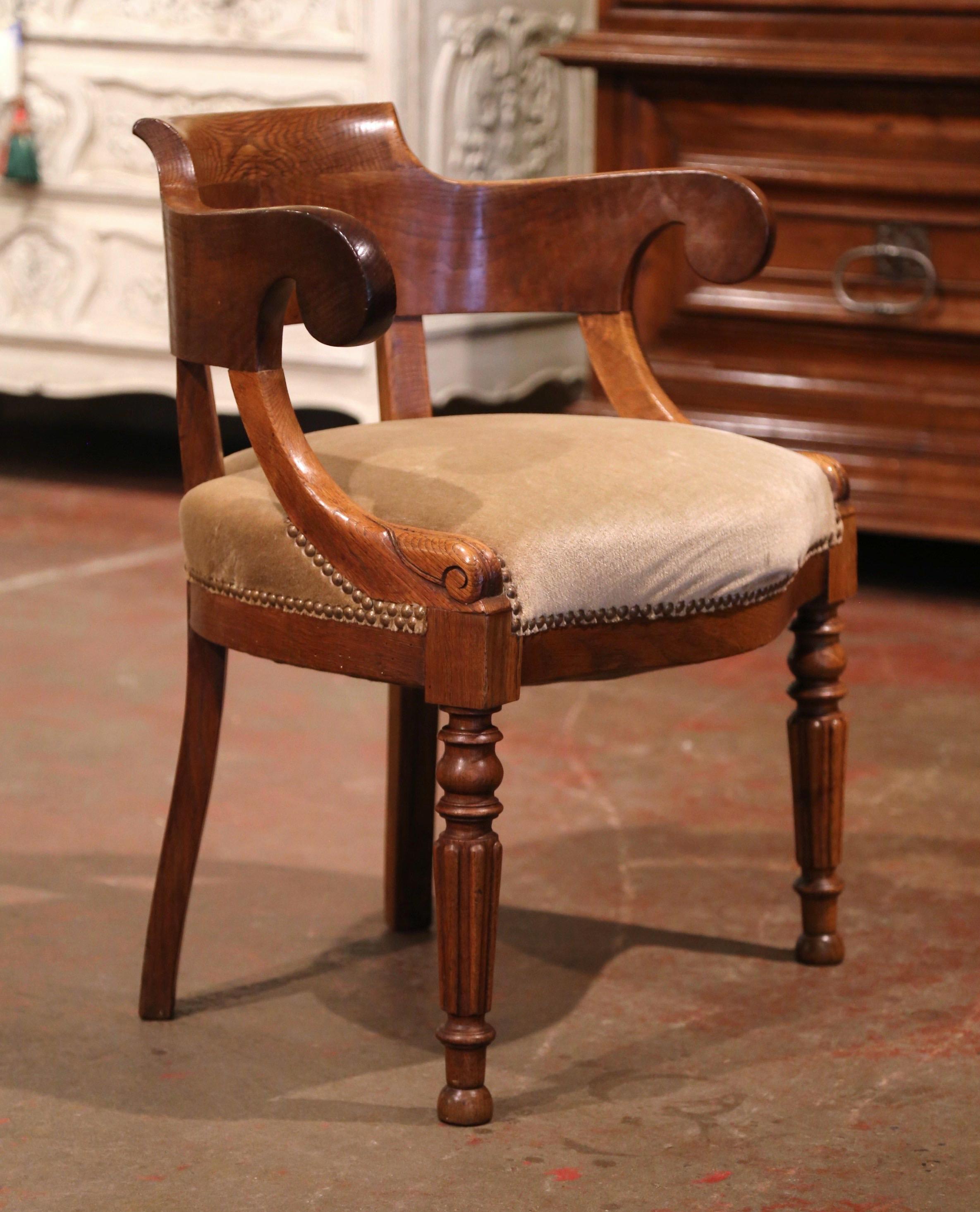 The sophisticated antique armchair would make an elegant yet subtle statement behind a man or woman's desk. Crafted in France circa 1880 and made of chestnut and oakwood, the carved armchair sits on front turned and tapered legs; the chair features