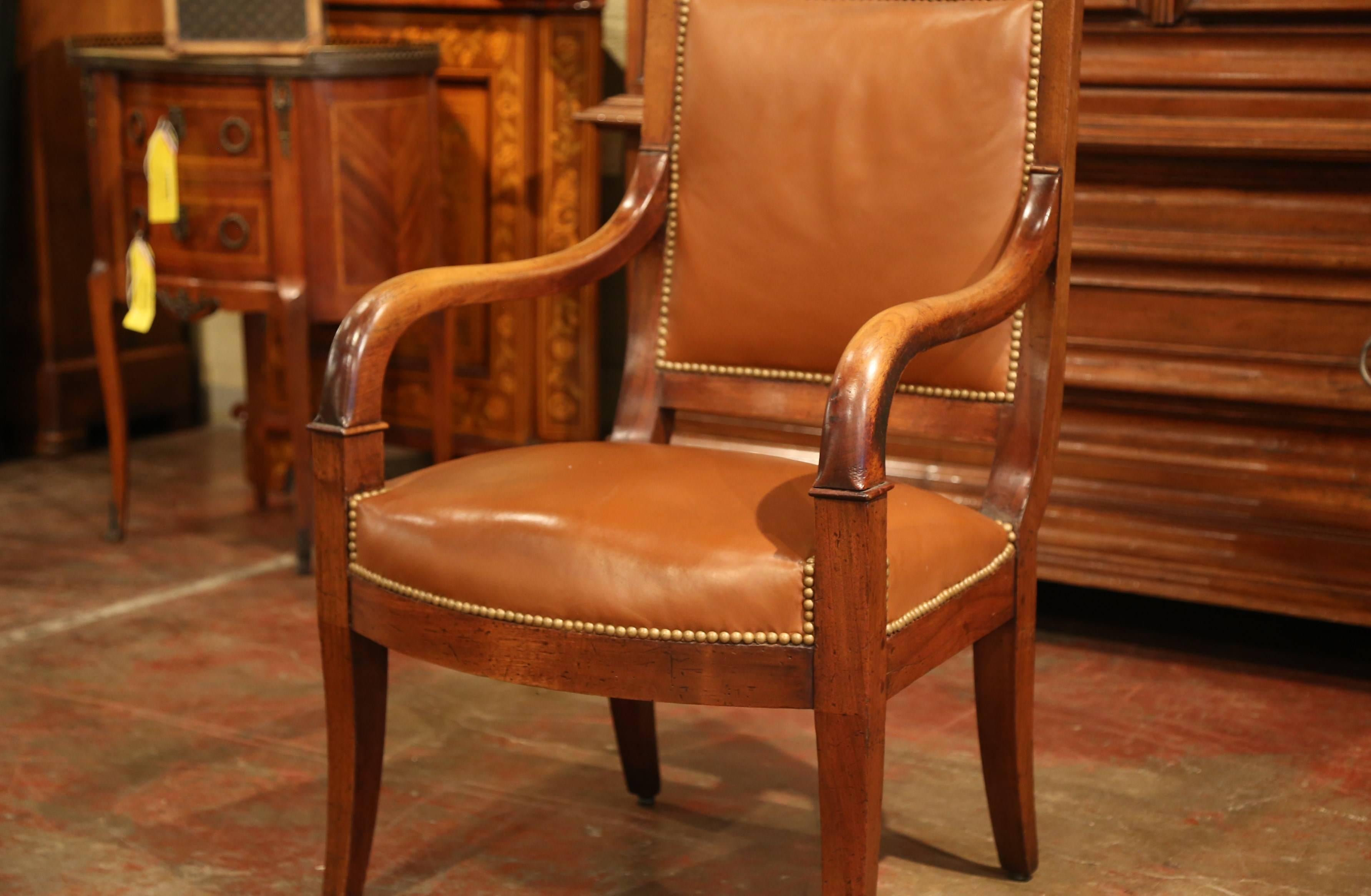 This elegant antique fruitwood armchair was crafted in Paris, France, circa 1850, the comfortable desk chair stands on curved legs, it features a square back and curved armrests. The armchair is upholstered with the original patinated light brown