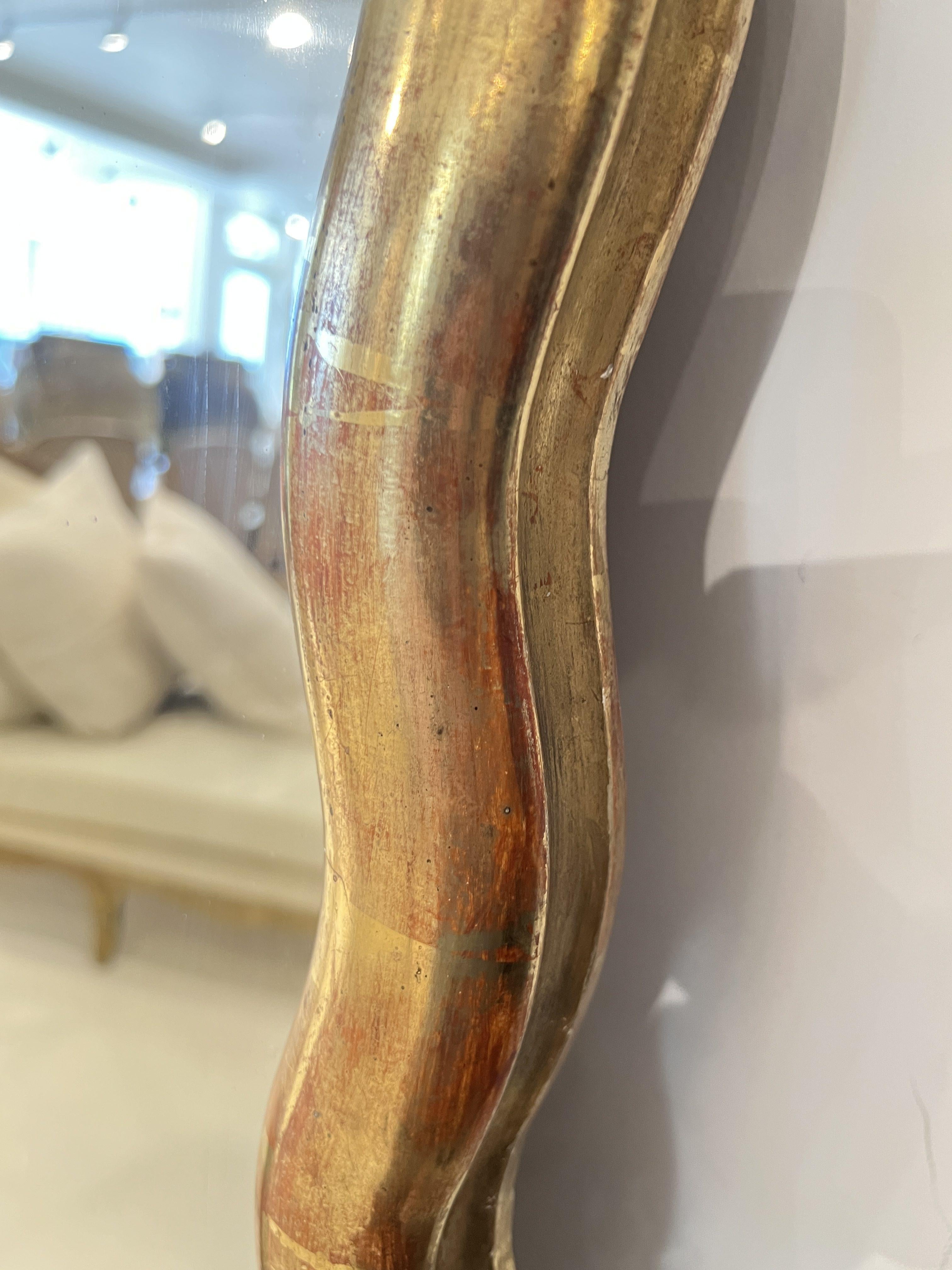 Un grande specchio francese del Direttorio con cornice dorata smerlata, che combina la simmetria neoclassica con curve sottili, offrendo un'eleganza sobria e un punto focale luminoso.