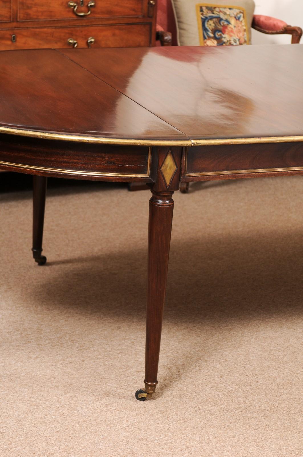 19th Century French directoire style mahogany dining table with brass details.