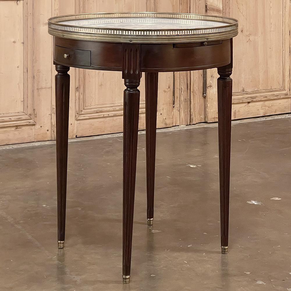 19th Century French Directoire Mahogany Marble Top End Table combines the tailored elegance of the Directoire style with the finest materials and incredible functionality! Ideal as a side table or a lamp table, it features a pierced brass gallery
