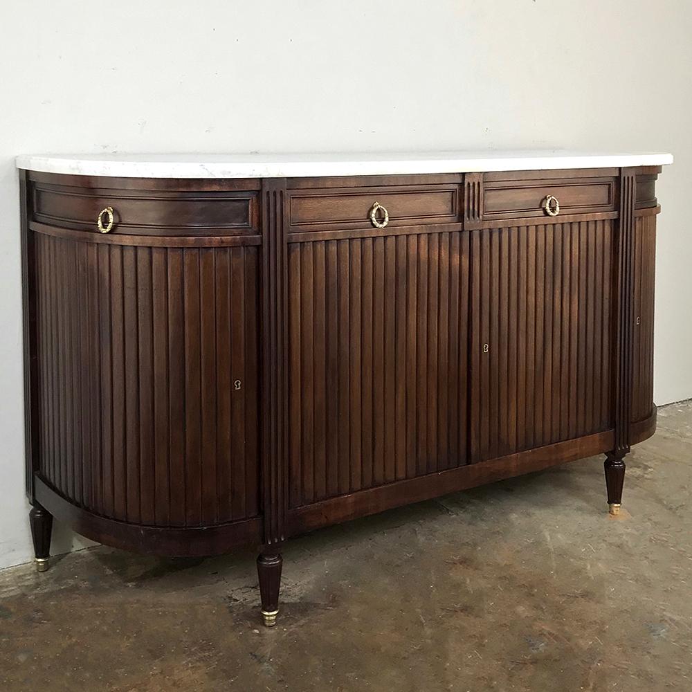 19th century French Directoire marble top buffet was handcrafted from fine imported mahogany and given tailored lines which includes rounded sides for a soft impact on the footprint of the room. Fluted pilasters provide a framework for the vertical