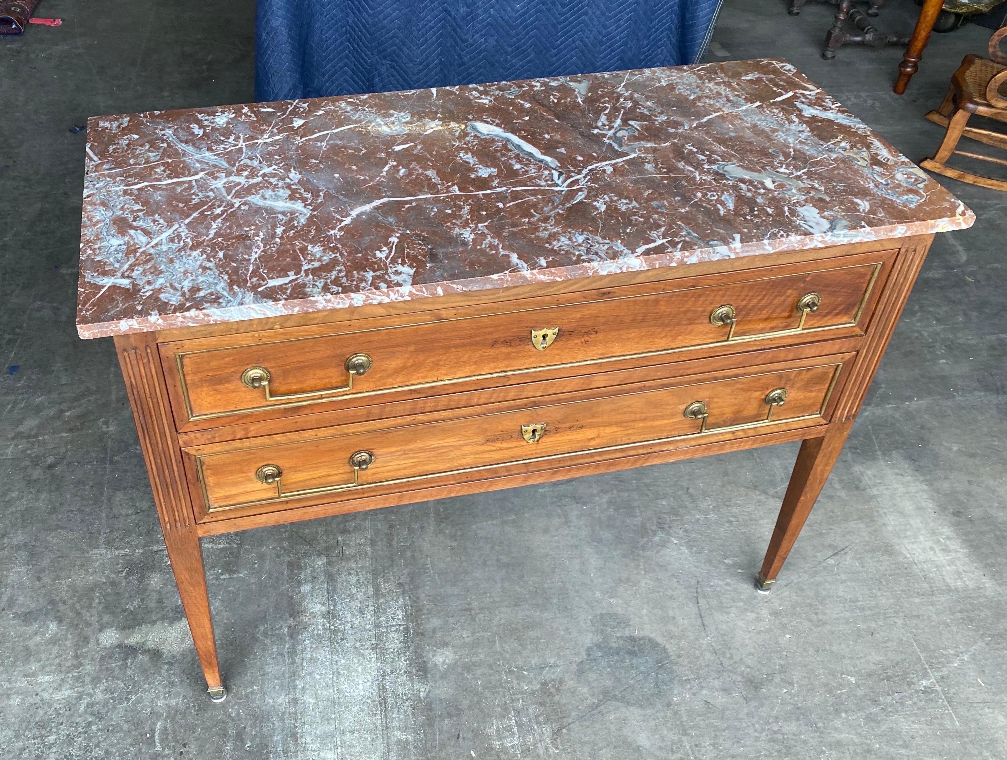 Great size 19th century French Directoire marble top commode. 2 Drawers encased with brass, surrounded by fluting and tapered legs.