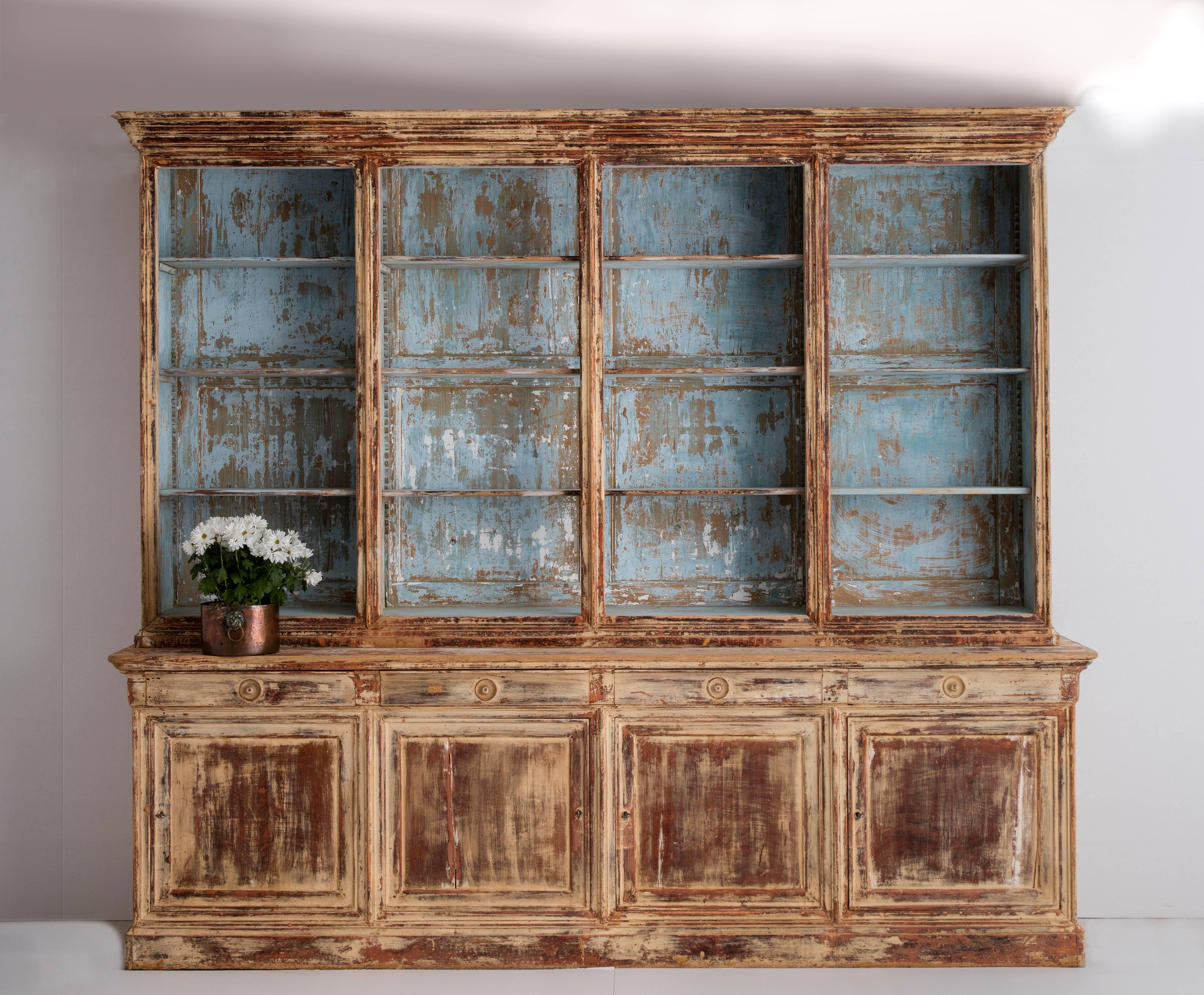 A monumental mid-19th century French Directoire style two-part bibliothèque (library) from the south of France in original blue, cream, and taupe paint. The upper library features three fully adjustable shelves for each of the four divided sections.