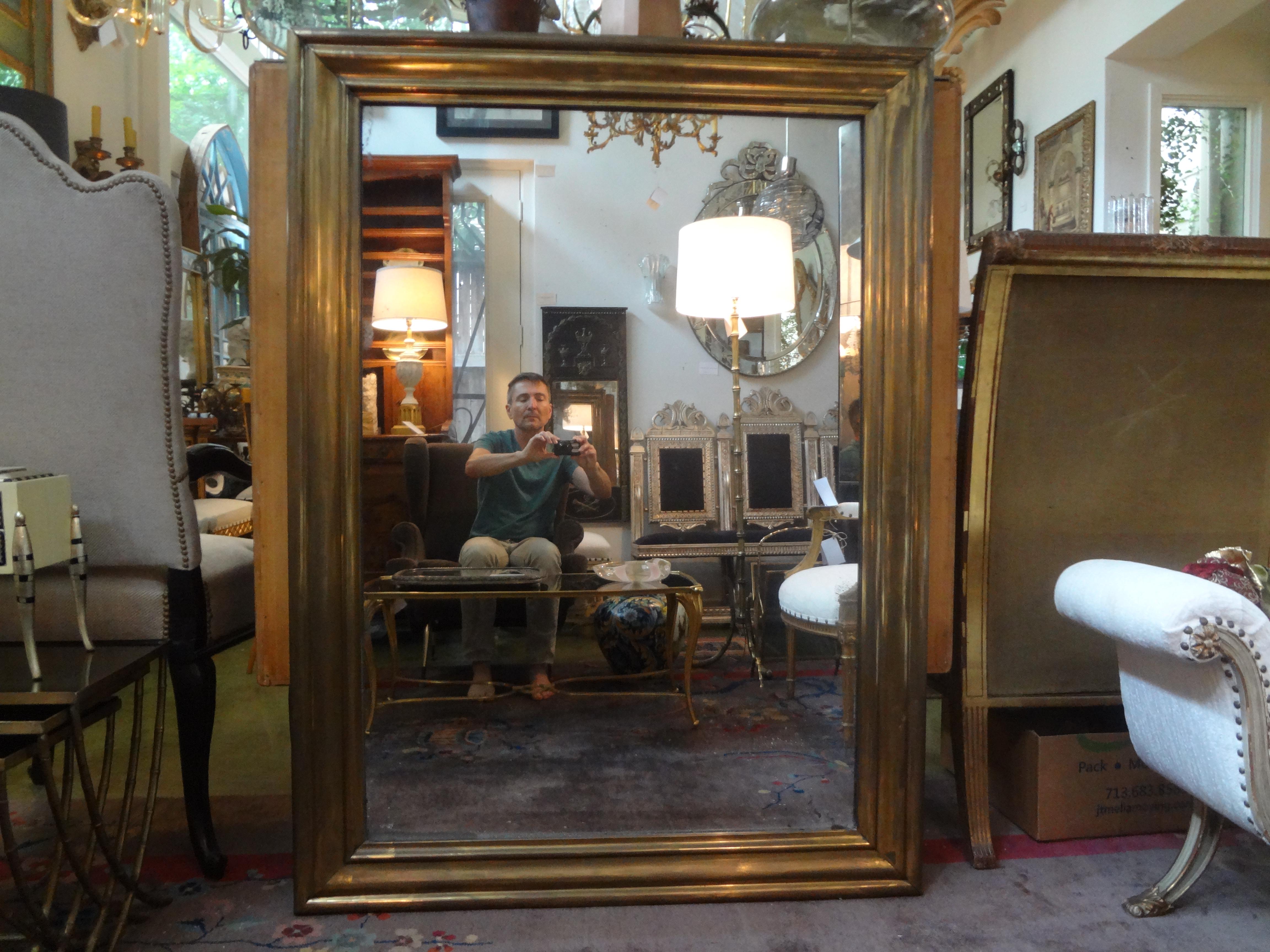 Large 19th century French Directoire style or Louis XVI style brass mirror with original wood back. This stunning full-length mirror has fabulous patina and would work well in a variety of rooms and interiors. It's possible to display this mirror