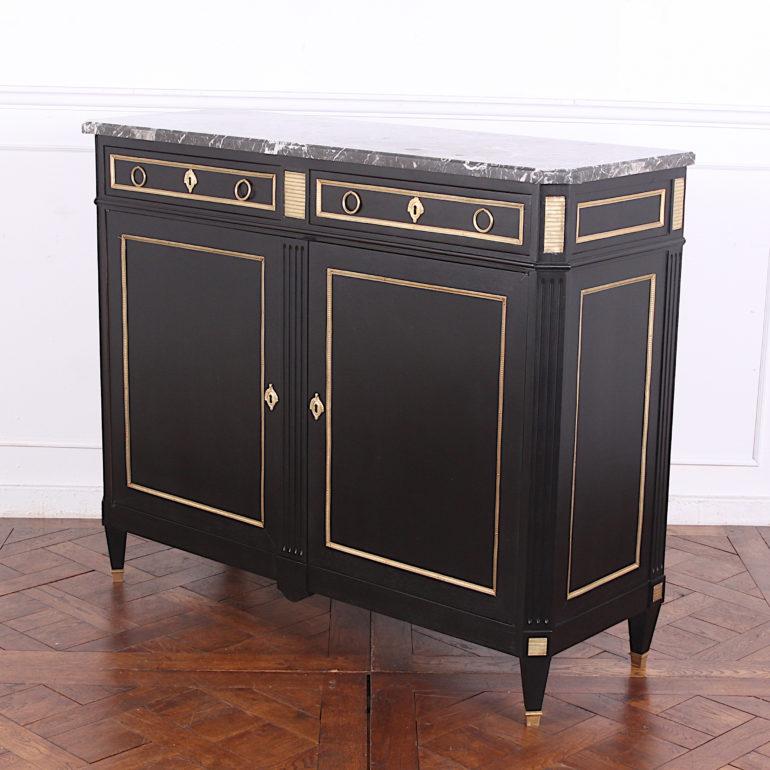 A 19th century French Directoire-style marble top buffet with a new ebonized finish and gilt mounts. A single adjustable shelf fitted to the interior (not shown in photos) The panels, doors and drawers are accented with gilt perimeter moulding. The