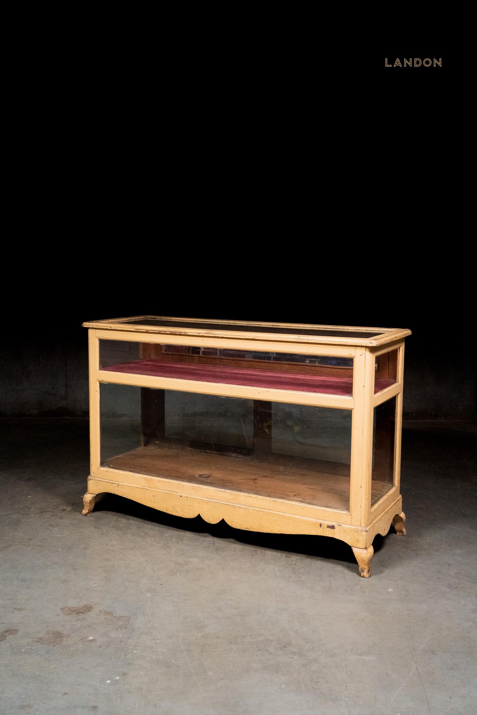 Originale vetrina da banco di un negozio di campagna con  Piedi in fusione, vernice originale color crema di burro, ferramenta e accessori.  vano apribile con vetro smussato. Si tratta di un pezzo costruito su misura, realizzato alla fine del XIX