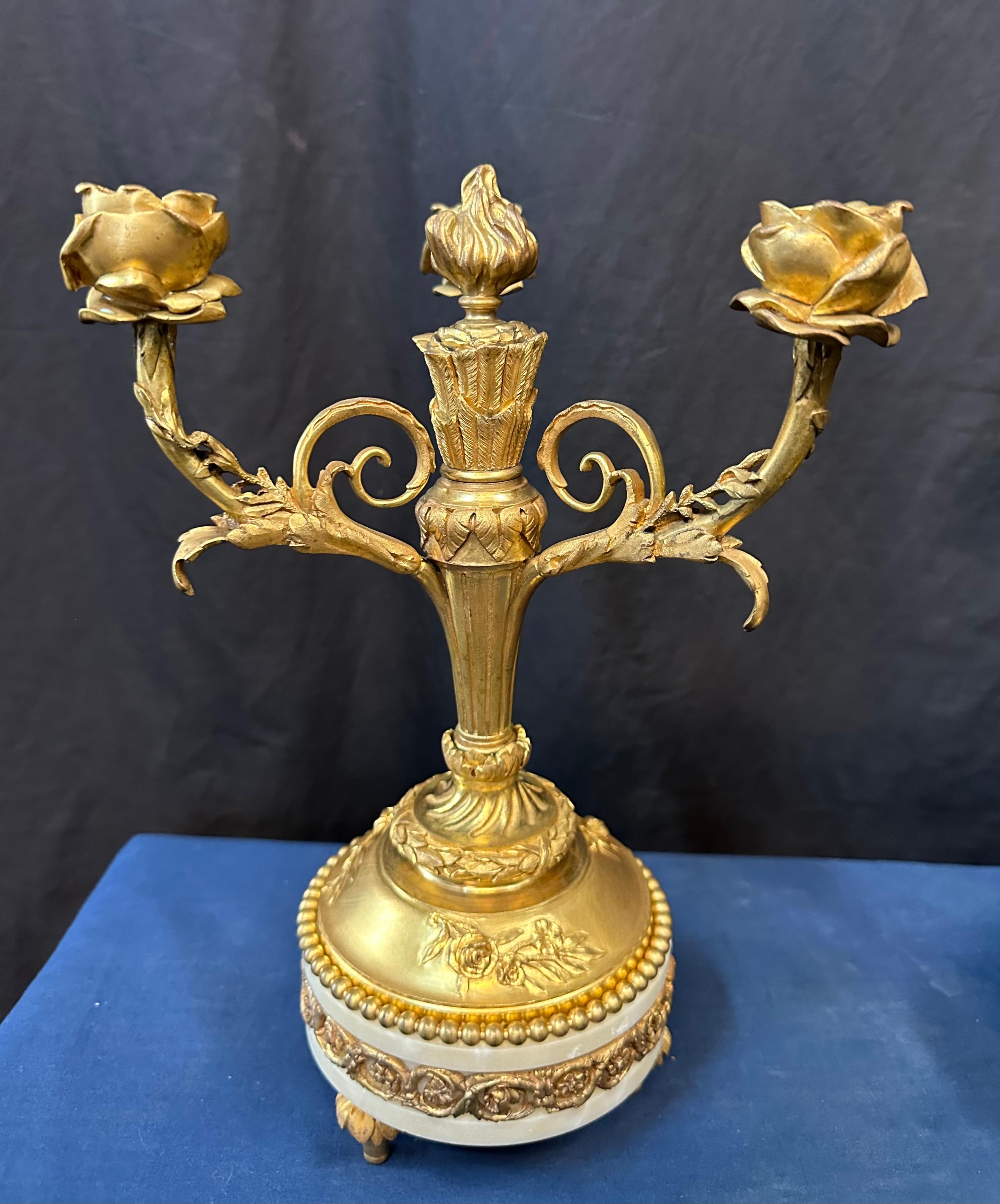 Questa rara coppia di candelabri francesi in bronzo dore' della metà del XIX secolo è splendidamente disegnata con un motivo di rose fiorite. Ognuno di questi dettagliati portacandele a forma di rosa è scolpito in modo unico e poggia su steli