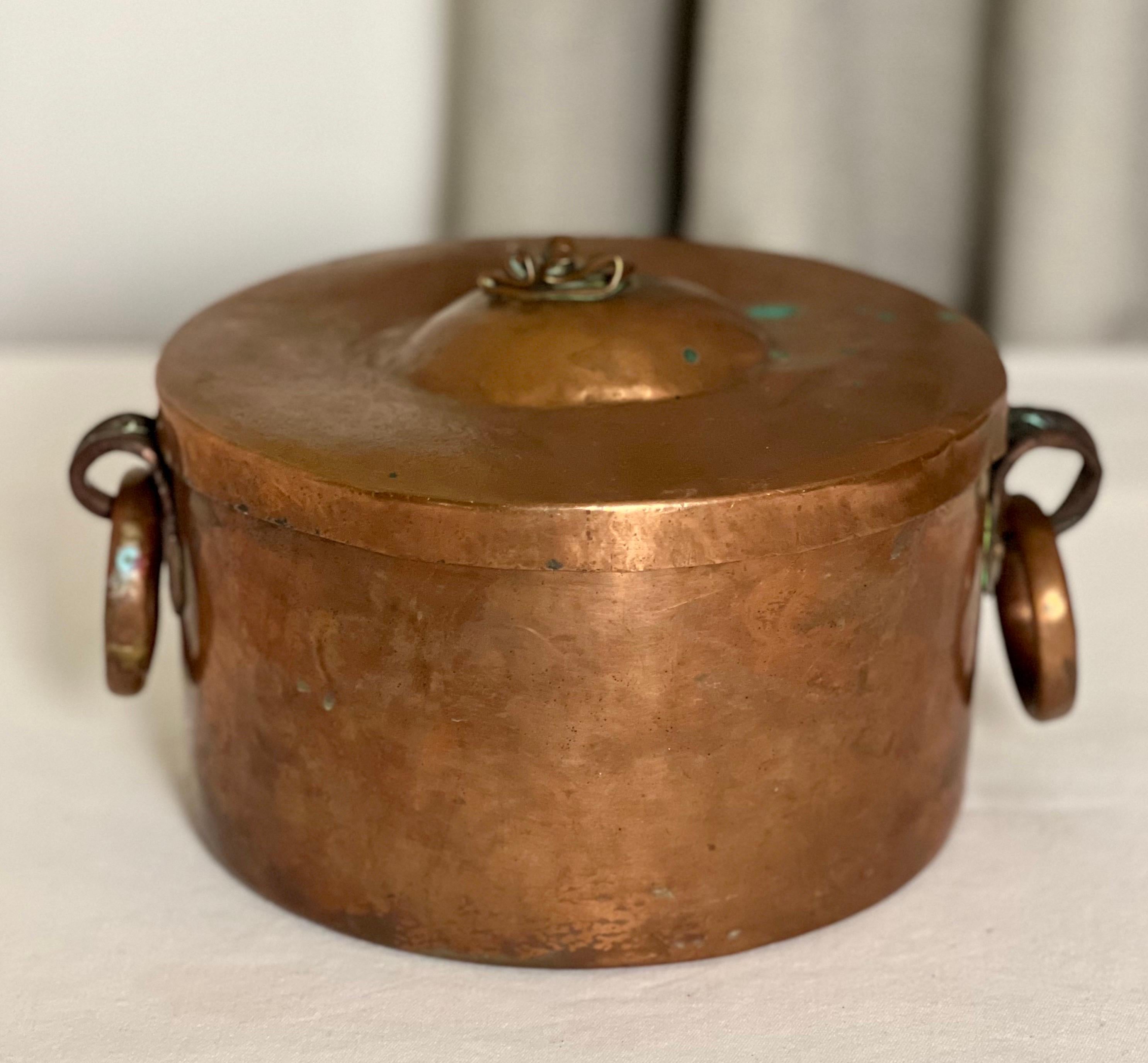 19th century French dovetailed copper braising pan or small pot with fitted lid.

This unique pot has two heavy drop ring copper handles with scrolled support brackets. A fitted lid features a charming, hand-formed knob giving it special character.