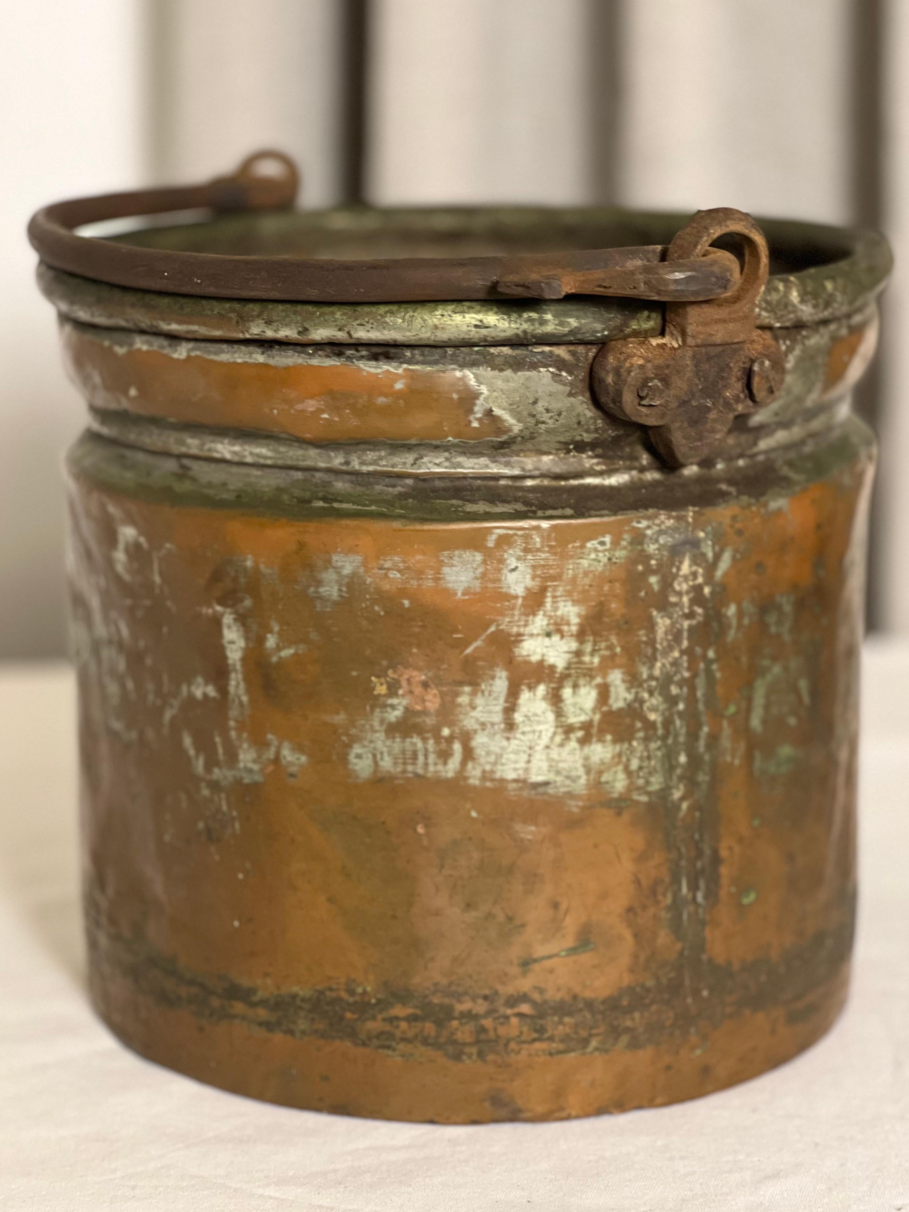 19th century French dovetailed copper bucket or jardiniere with handle.

Fantastic bucket from the Southwest of France most likely used as a milk churn. It has a snake form wrought iron handle and great patina. The dovetail construction is a