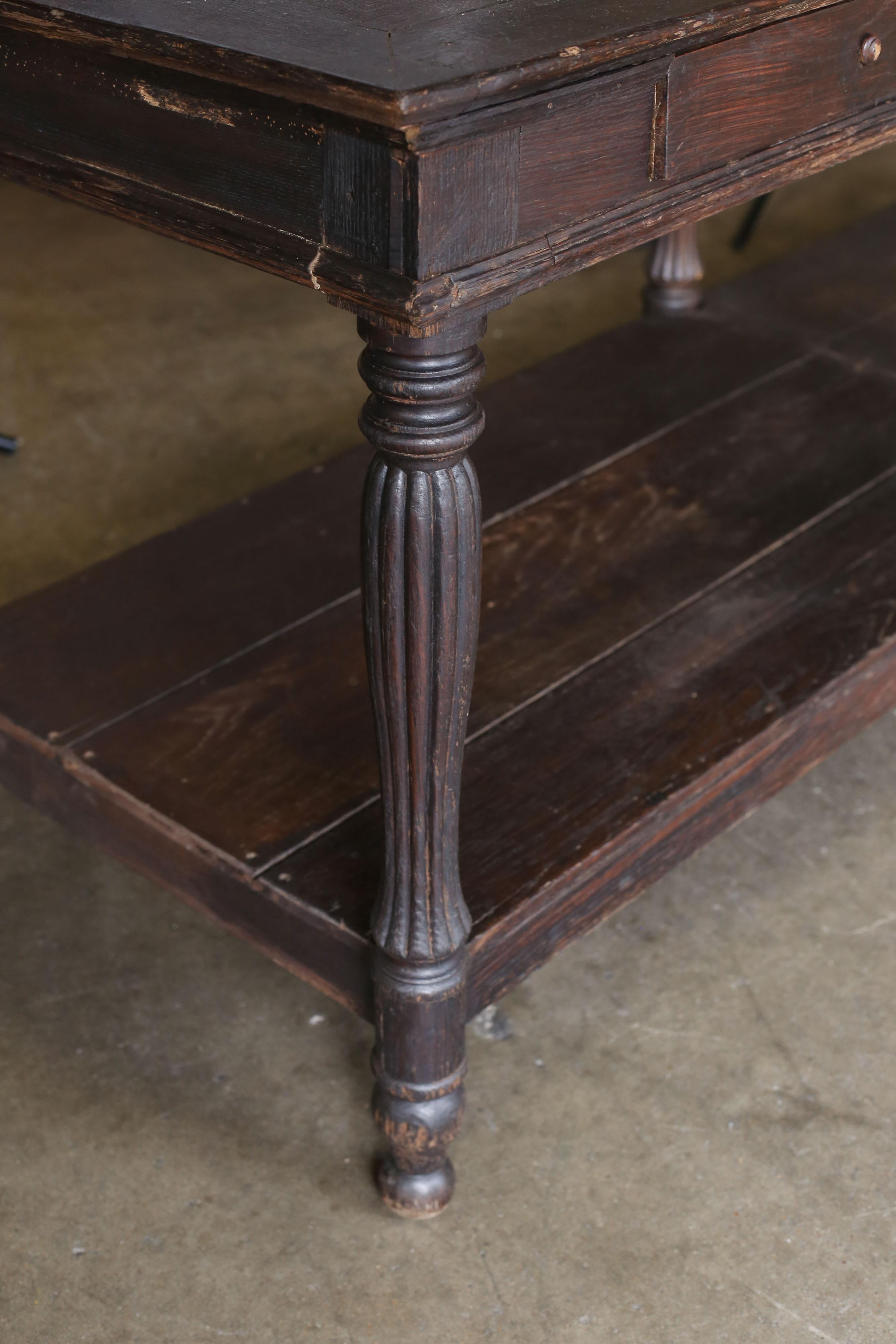 19th century French draper's table with a bottom shelf and two drawer's. Straight from a shop in the north of France. There is some old insect damage to some of the apron (see picture).
