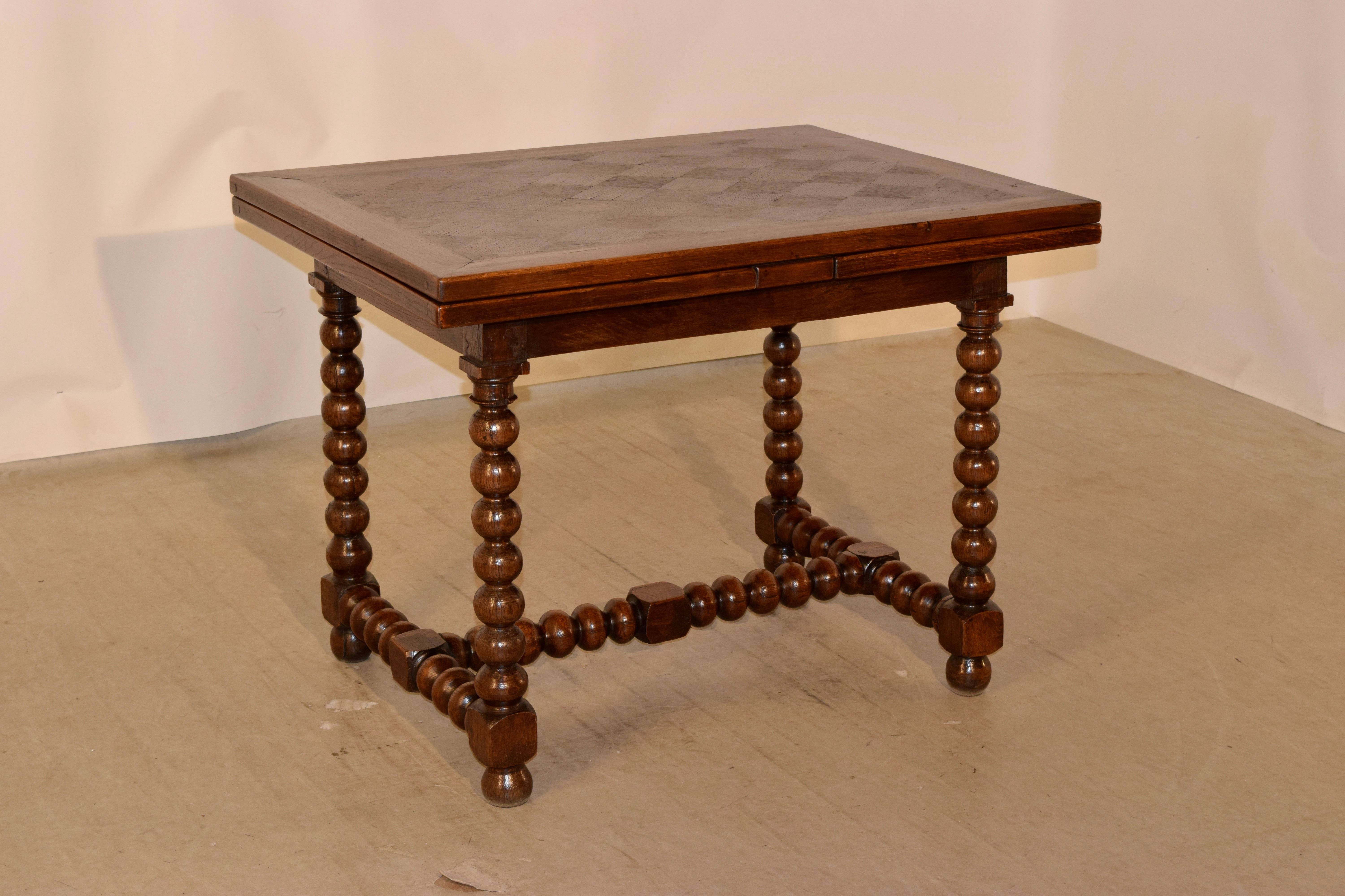 19th century oak draw leaf table from France. The top and leaves have lovely parqueted central banded panels, following down to a simple apron and supported on hand-turned bobbin pattern legs, joined by matching stretchers. Raised on hand-turned