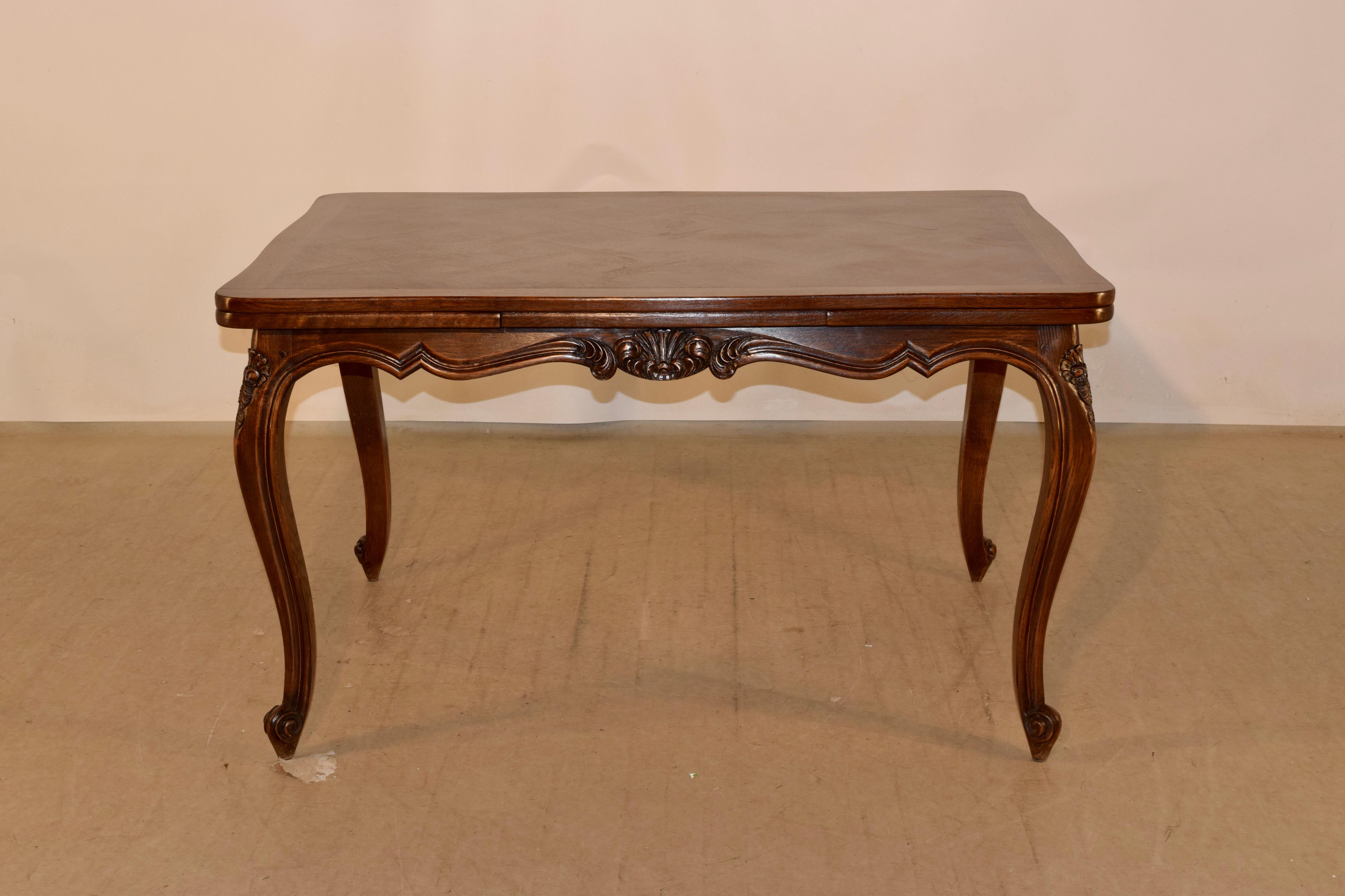 Late 19th century French draw leaf table made from oak with banded and parqueted top and leaves following down to a hand scalloped and carved decorated apron and supported on hand carved cabriole legs with carved shell decorations on the knees and