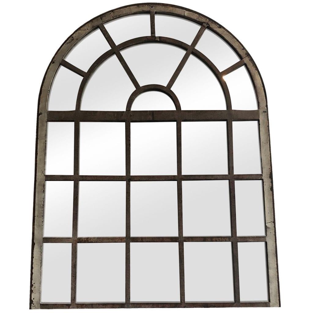 An antique French orangerie mirror with an arched top, in good condition. The wall mount structure has a cast iron antique frame and newly inserted mirrored panels. The antique wall decor represents the Renaissance Revival time period. Wear