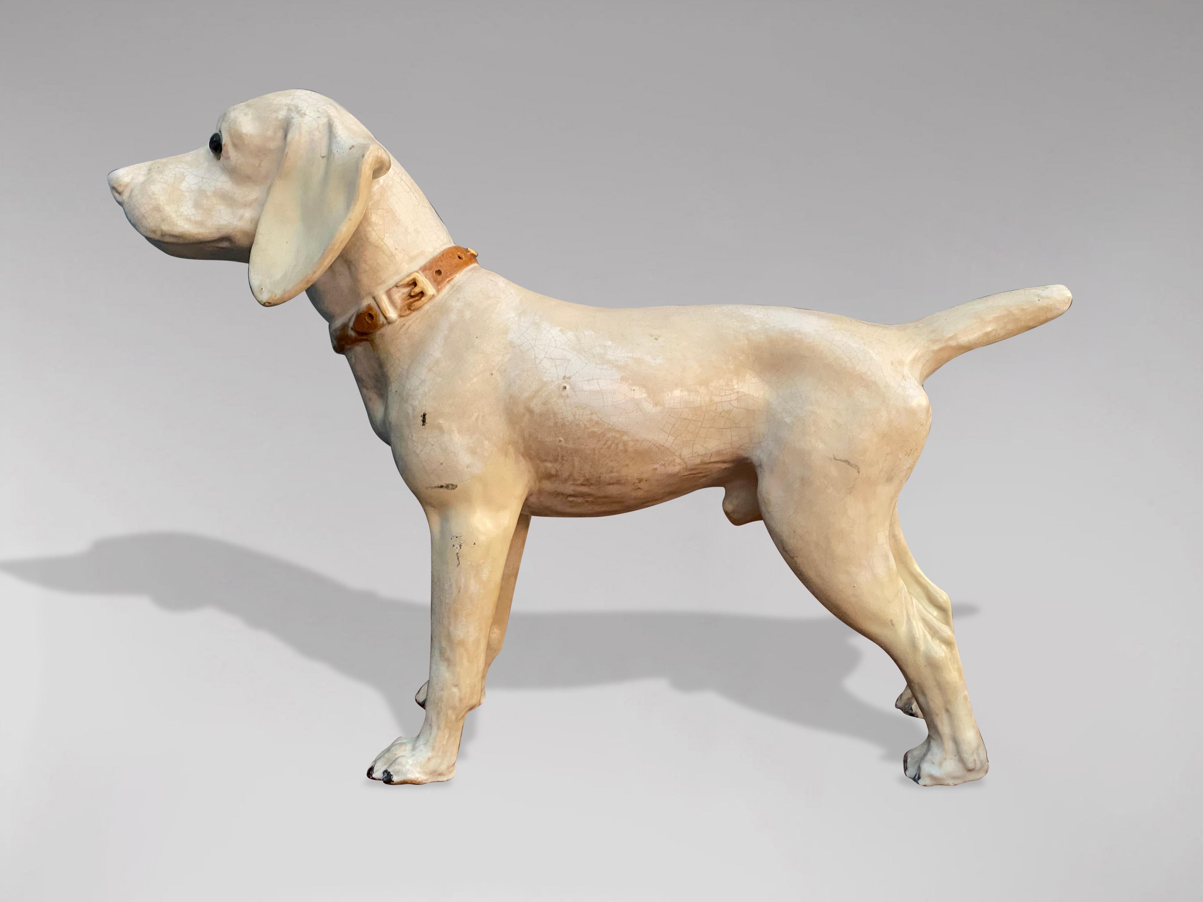 A great looking late 19th century French dog sculpture in earthenware from Bavent in Normandy. The dogs coat of different shades of white as well as its expressive look testifies to the quality of its craftsmanship. In perfect and original condition