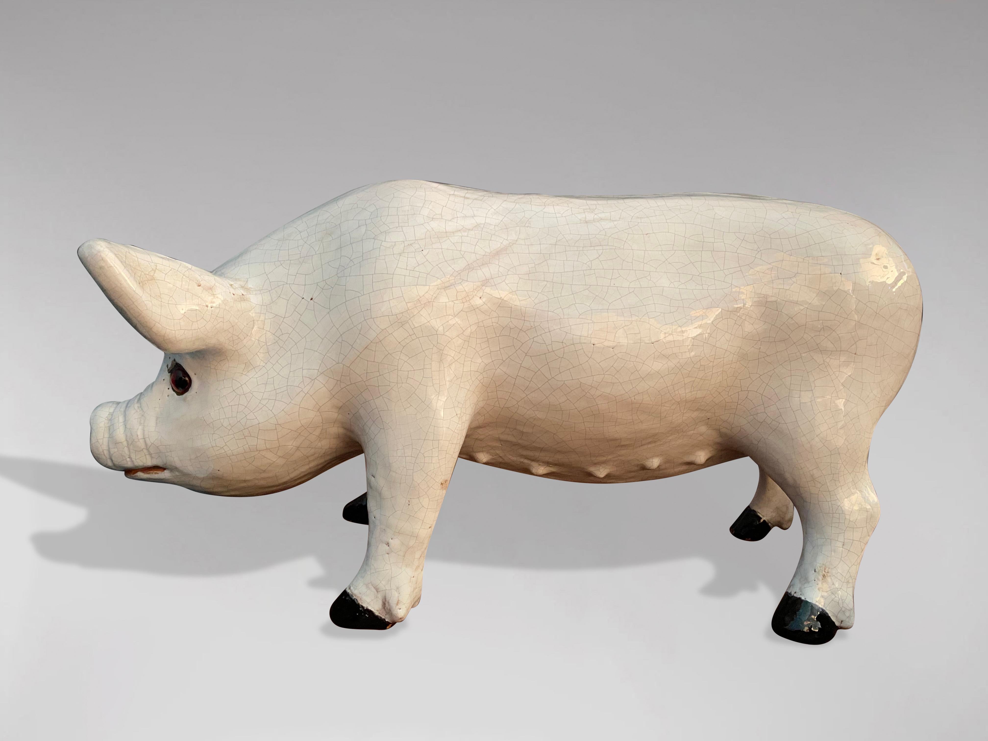 A great looking late 19th century French pig sculpture in earthenware from Bavent in Normandy. The pig of different shades of white as well as its expressive look testifies to the quality of its craftsmanship. In perfect and original condition with