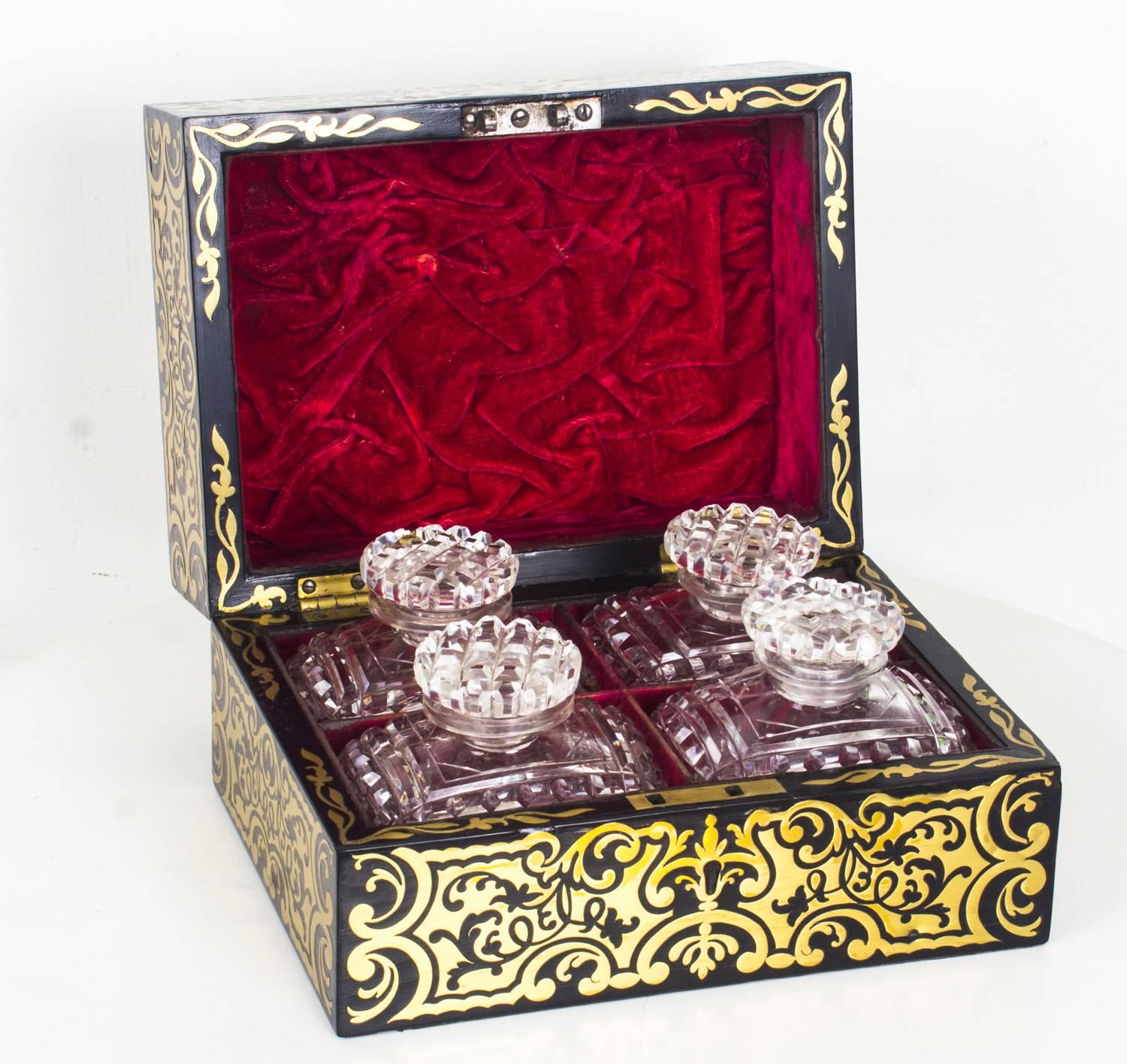 This is a fine antique French ebonised cut brass Boulle travelling dressing table box with four cut glass perfume bottles, circa 1860 in date.

The rectangular box is decorated with delicately cut brass foliate, scroll and strapwork decoration