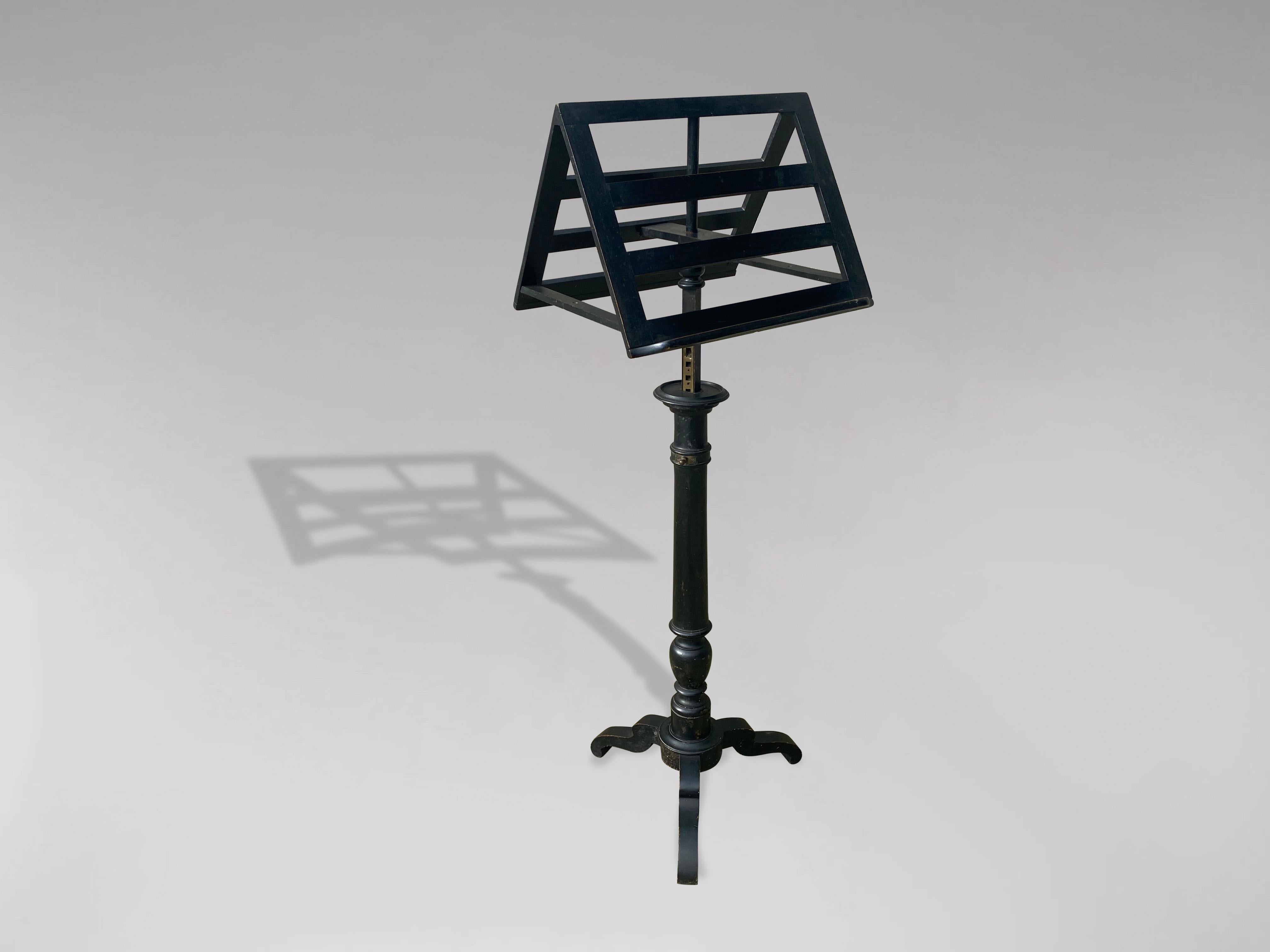 A late 19th century French ebonised duet sheet music with sturdy resting surfaces on each side for sheet music or books. The stand can be adjusted for height using the original brass hardware over a turned wood and fluted column ending in a