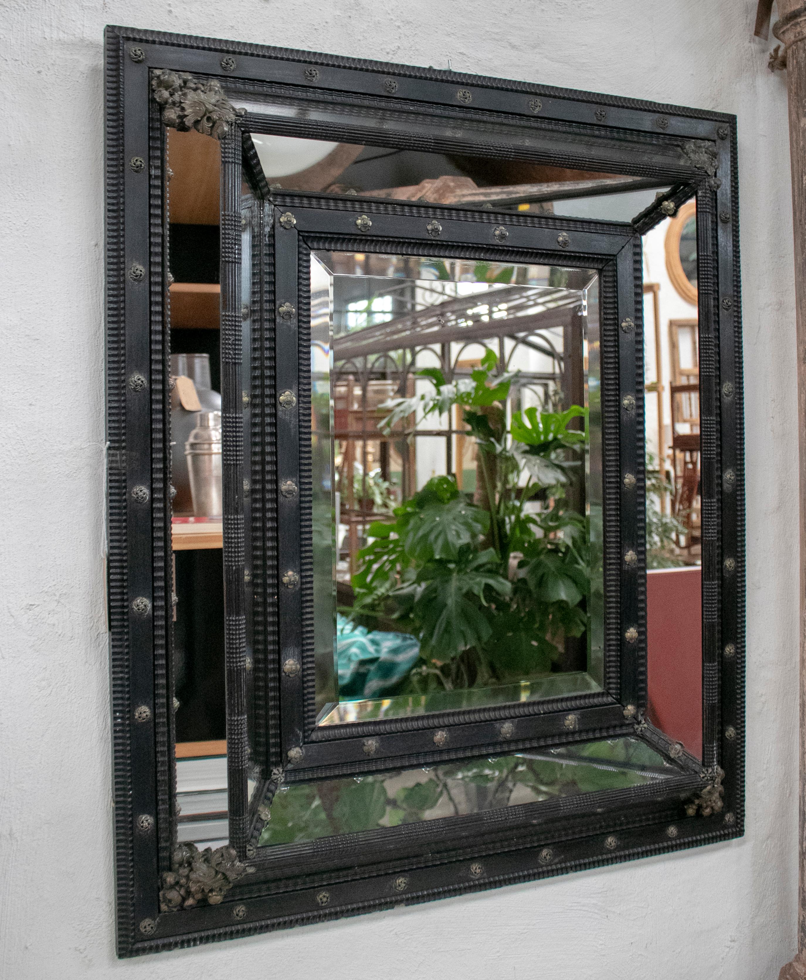 19th century square French ebonized mirror with bronze decorations.
