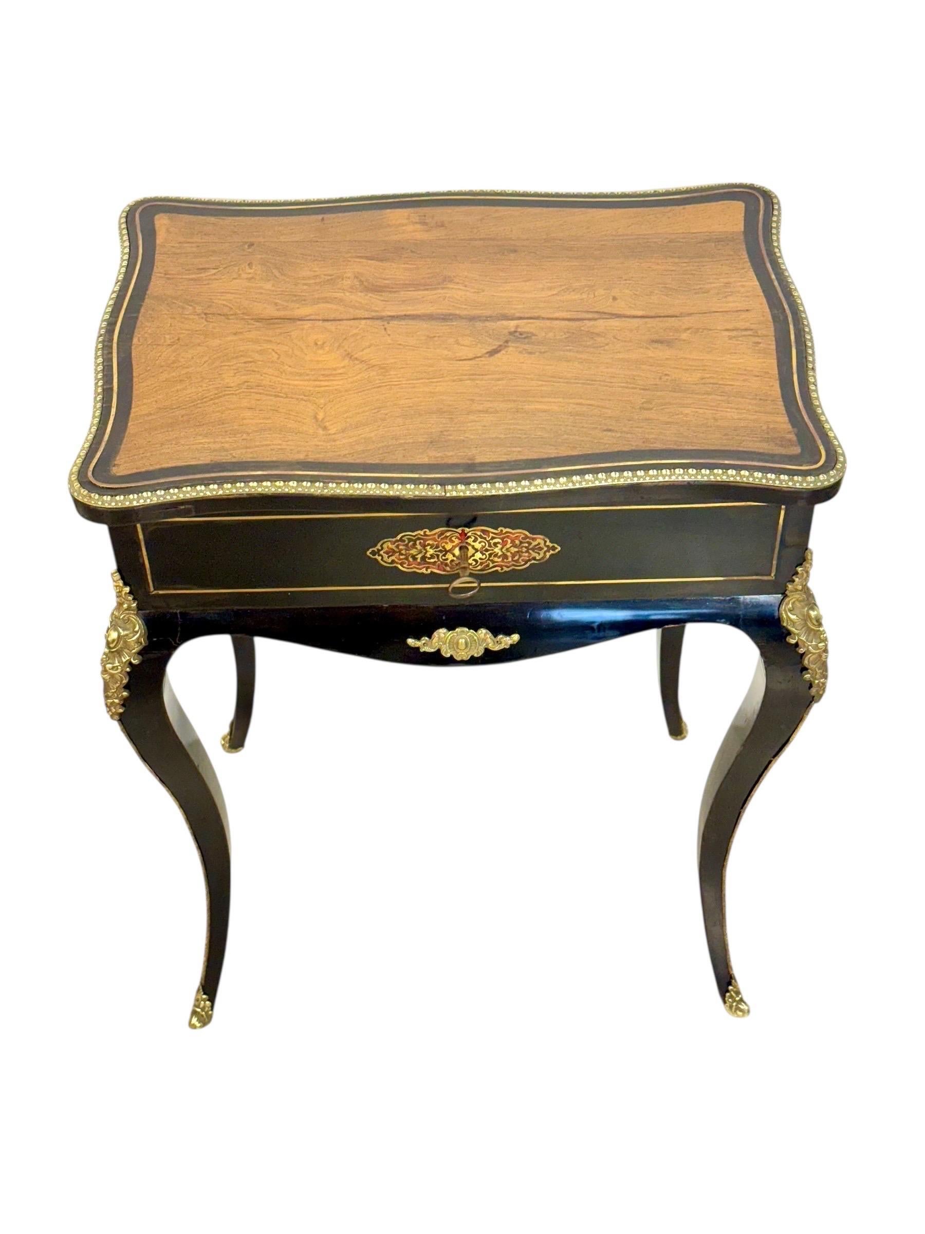 Table de toilette française raffinée du XIXe siècle en noyer ébonisé, ornée de fines montures en bronze doré de style Napoléon III. La finition noire profonde, obtenue par l'ébonisation du bois de noyer, contraste magnifiquement avec les appliques