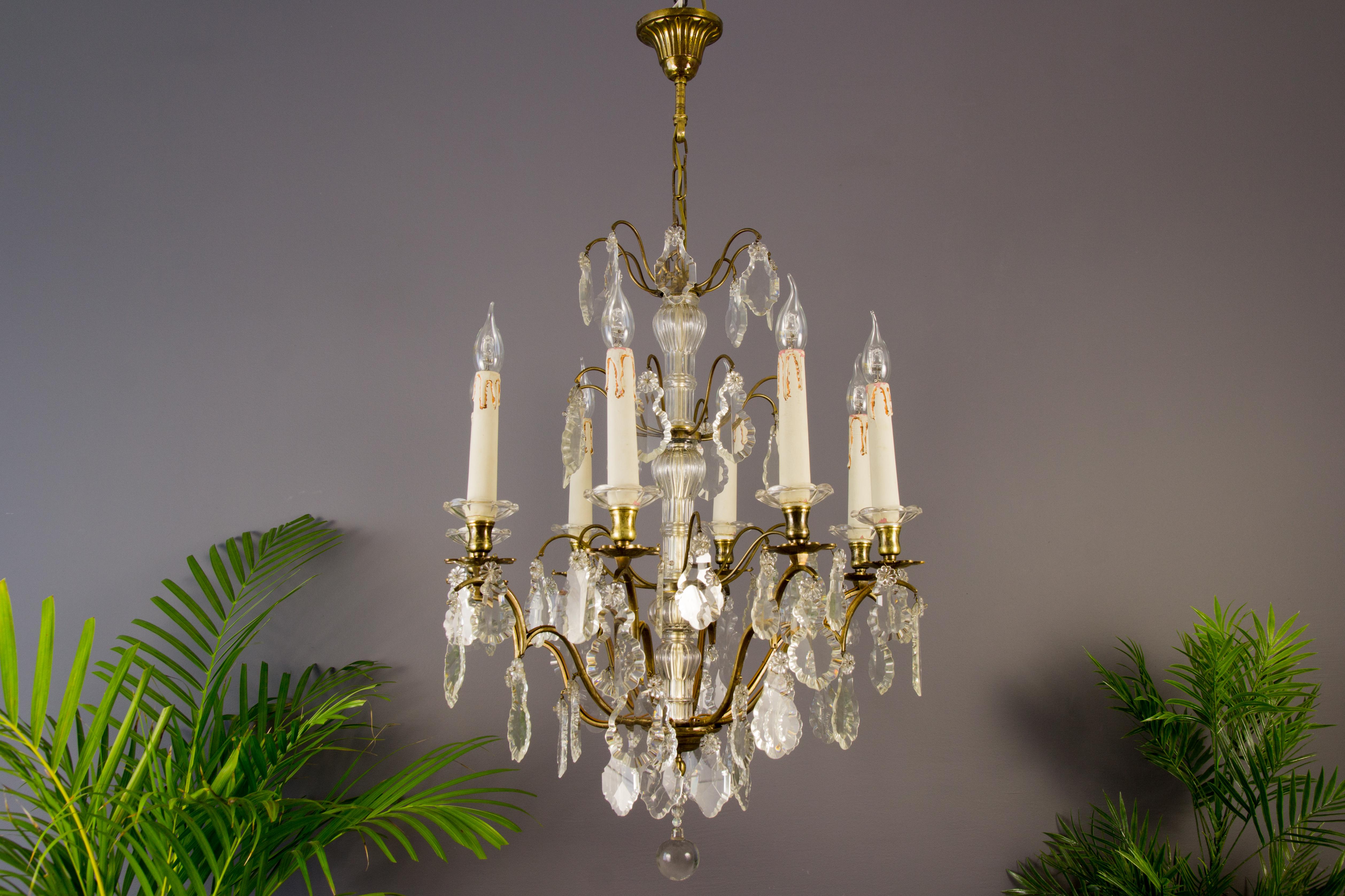 A stunning crystal and a brass chandelier made in France in circa 1890s. Originally crafted for 8 candles, this antique chandelier has been electrified. Eight brass arms with flower-shaped brass and crystal bobeches, each with a socket for an E 14