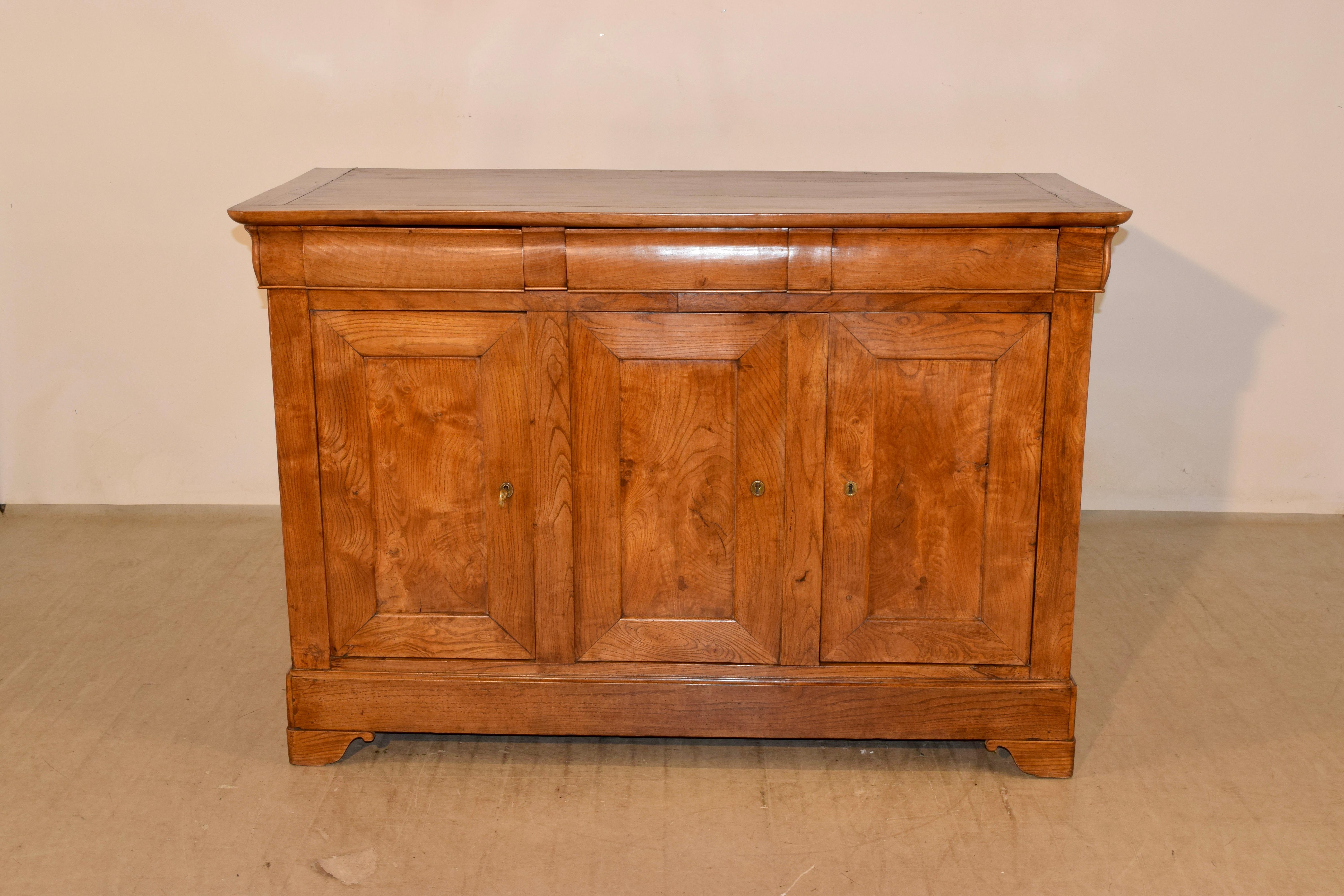 19th century elm enfilade from France with wonderful graining throughout the case. The top is made up of planks and has banded edges, following down to two drawers over three dpaneled doors, which open to reveal shelving. The sides are simple and