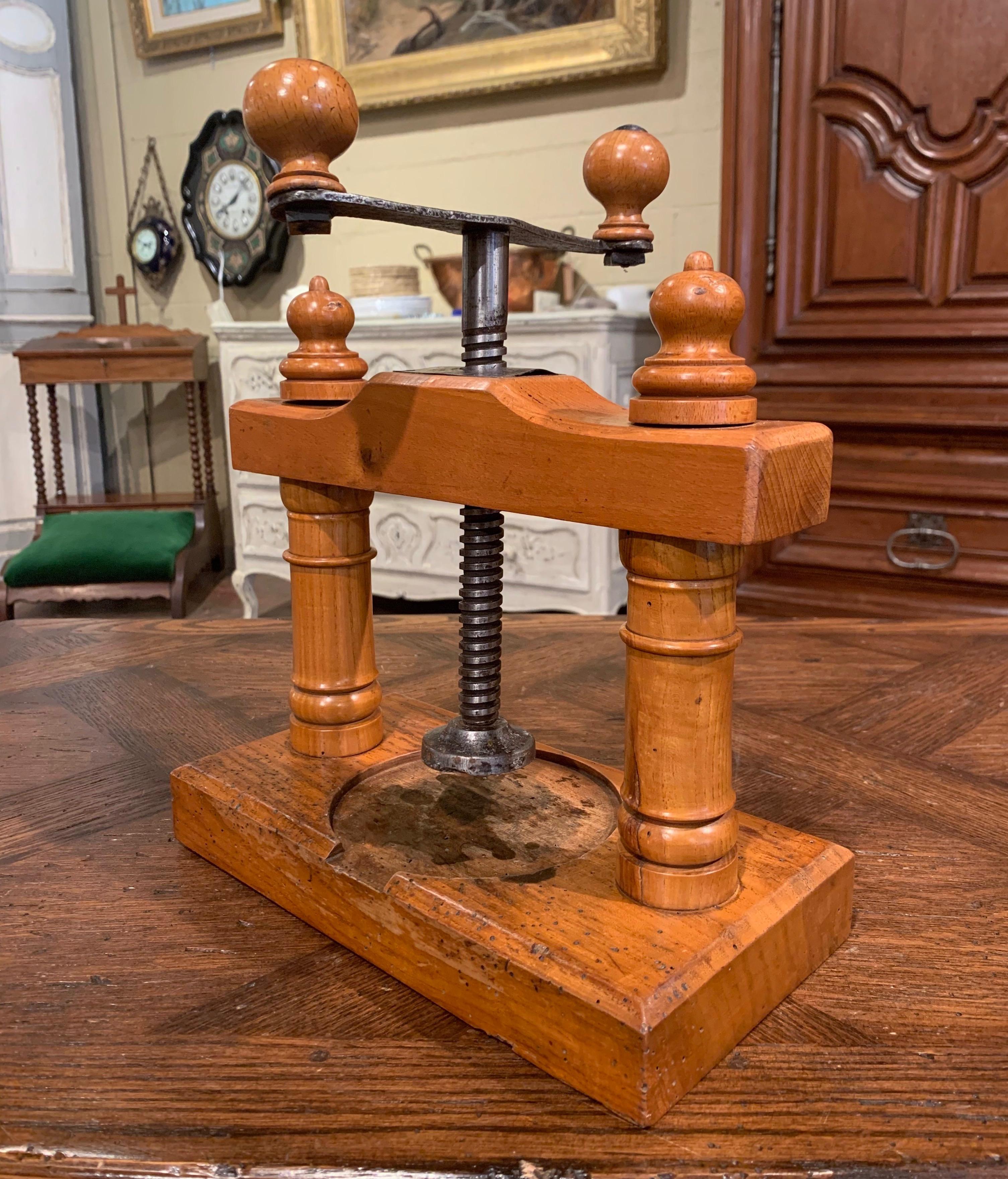 Decorate a kitchen counter with this elegant antique press devise. Crafted in France circa 1880, the fruit wood utensil stands on a rectangular base and features a iron twist screw with top handle to press either fruit or cheese. The piece is in