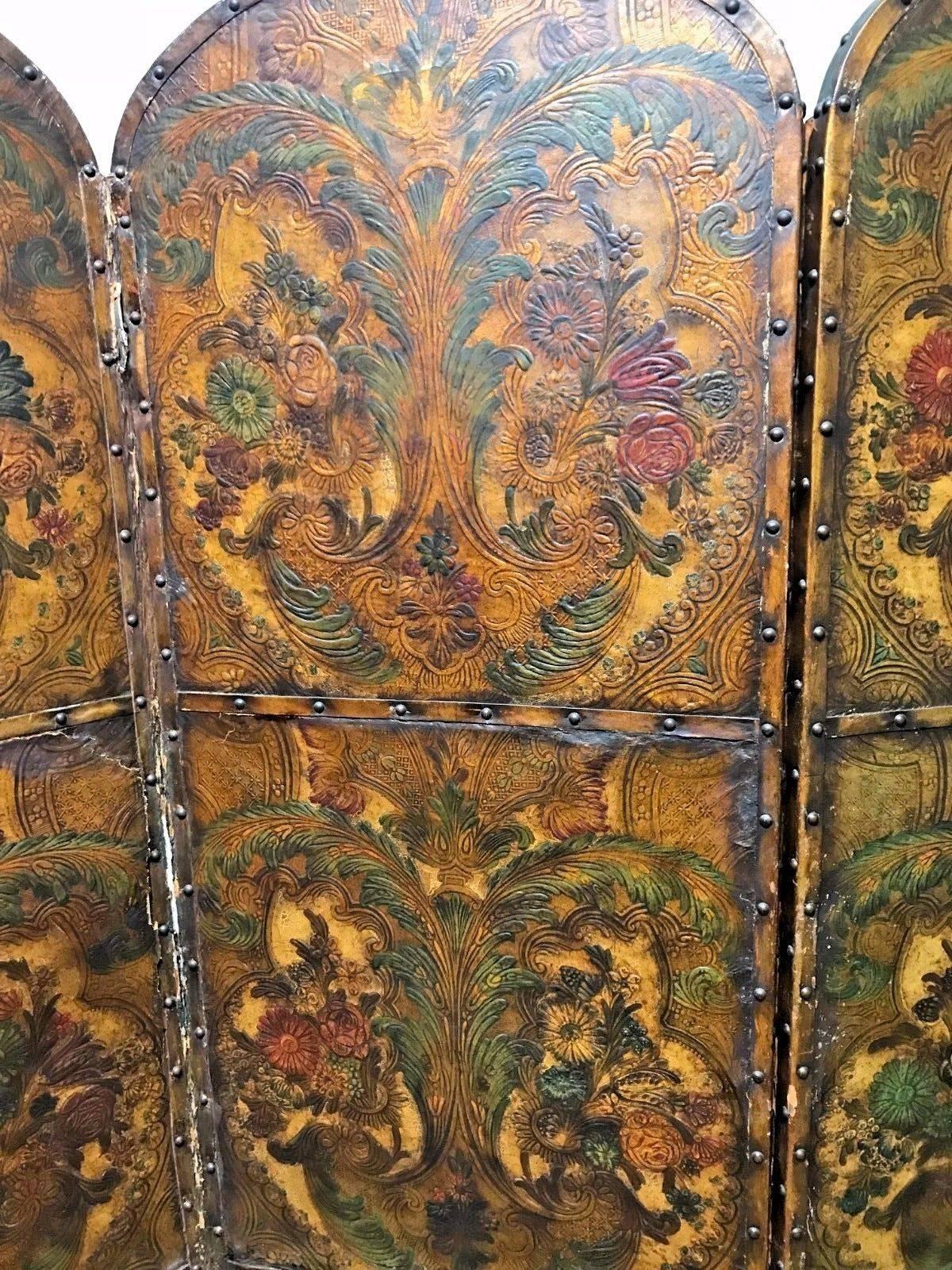 Charming 19th century French embossed leather and polychrome decorated four panel folding screen with nailhead trim and having outstanding designs overall of scrolling leaves, plus an abundance of colorful flowers petals and sprays.



Each