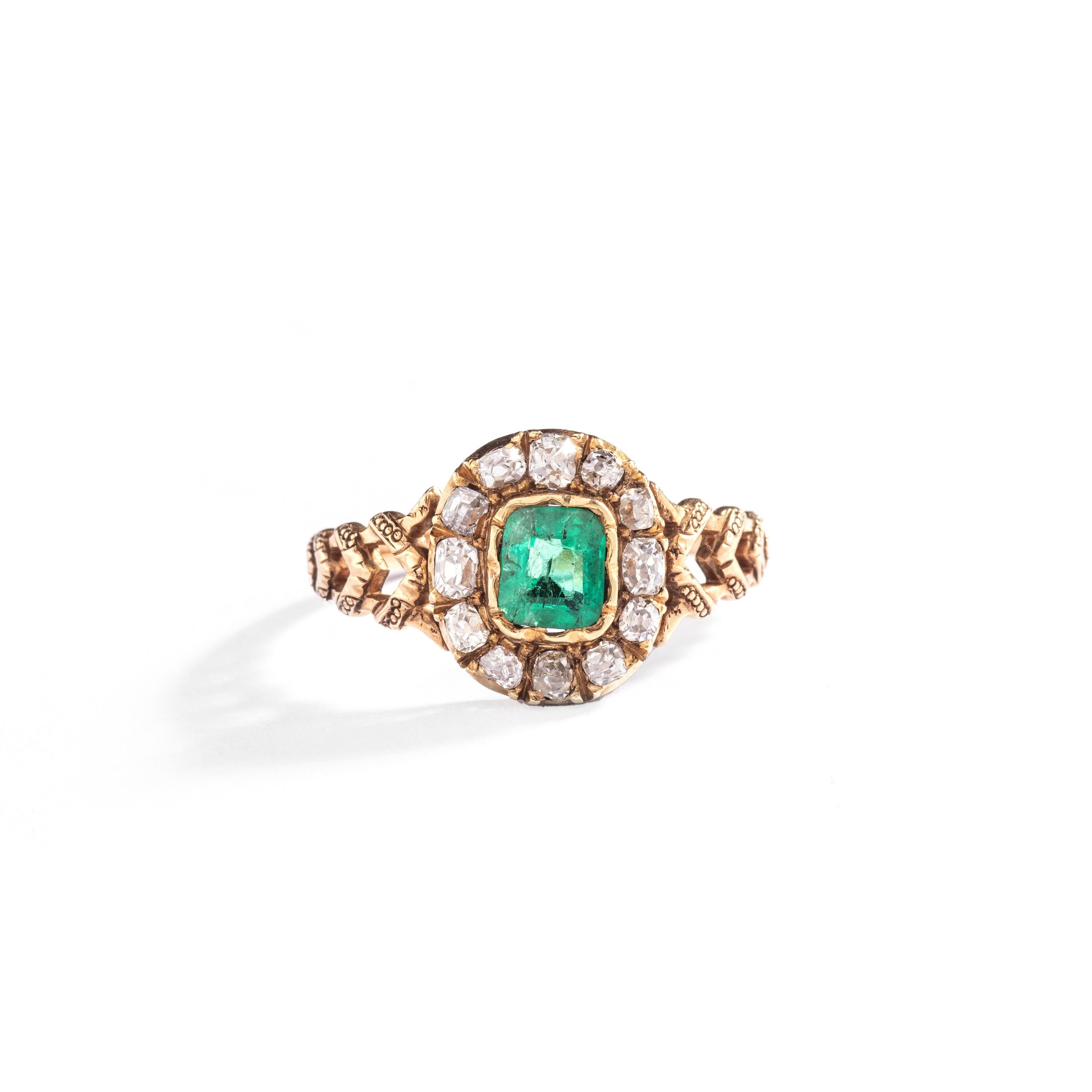 Presenting an exquisite piece of history, we have an antique emerald-cut emerald mounted in an engraved yellow gold ring surrounded by old mine diamonds.

This captivating ring dates back to the late 19th century, showcasing the grandeur and