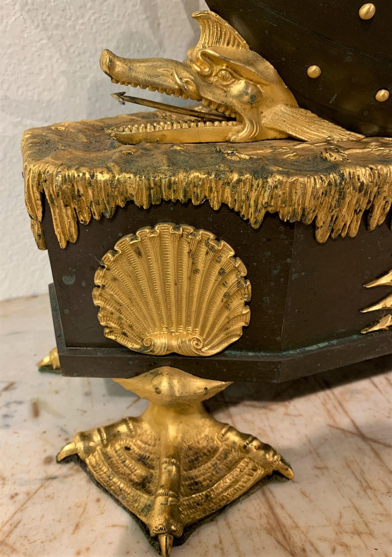 Extraordinary 19th century French Empire gilt and patinated bronze allegorical mantel clock. Chronos (Father Time) is portrayed in a boat holding an hourglass and scythe. The boat is being steered by Amour. The base fashioned as an oceanic surface,