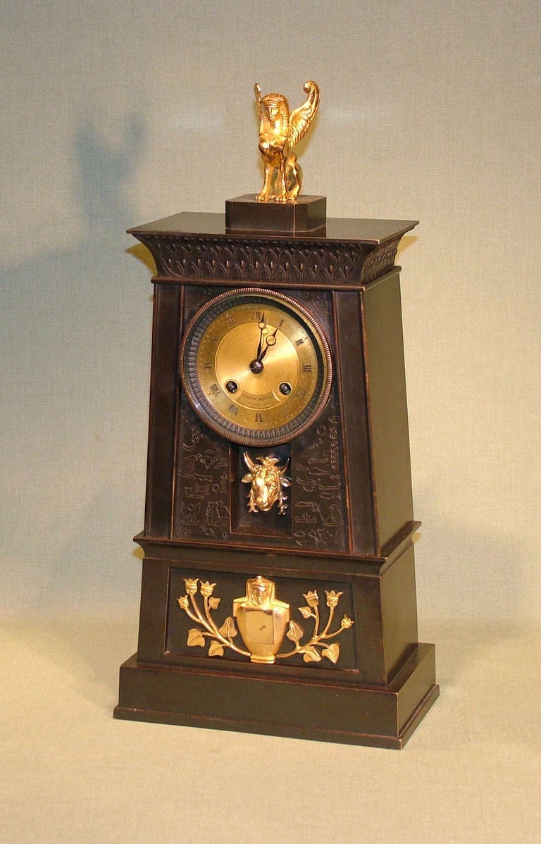 A French Empire bronze and ormolu clock in the Egyptian style with 8 day silk-suspension striking movement by Hemon a Paris, also marked “Ledure Bronzier”, enclosed in bronze obelisk tower decorated with hieroglyphics and mounted with recessed