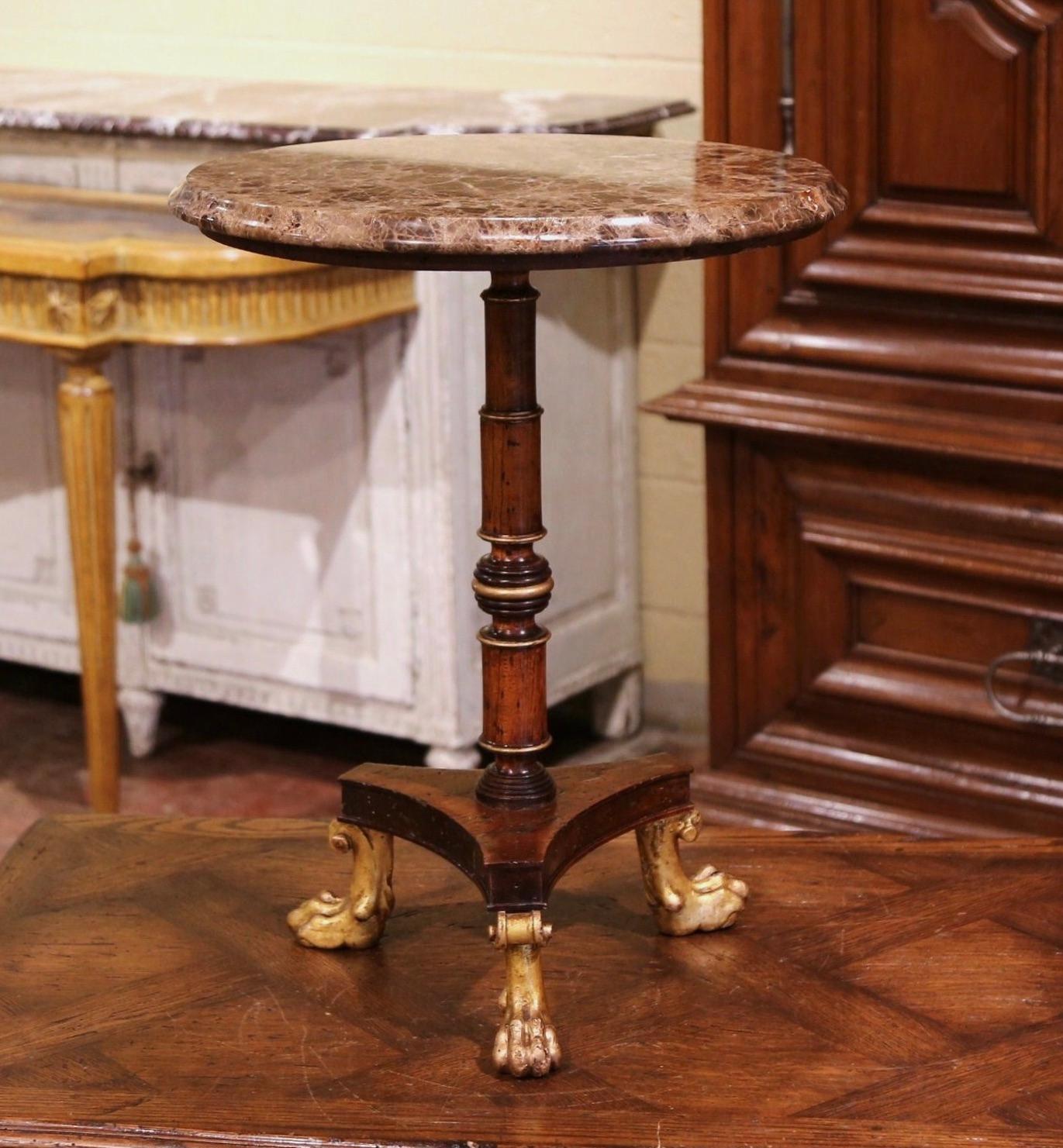 This elegant antique fruit wood and marble table was created in Paris, France, circa 1880. The pedestal stands on an intricate turned stem ending with three carved paw feet over a curved triangle base. The top is dressed with a circular variegated