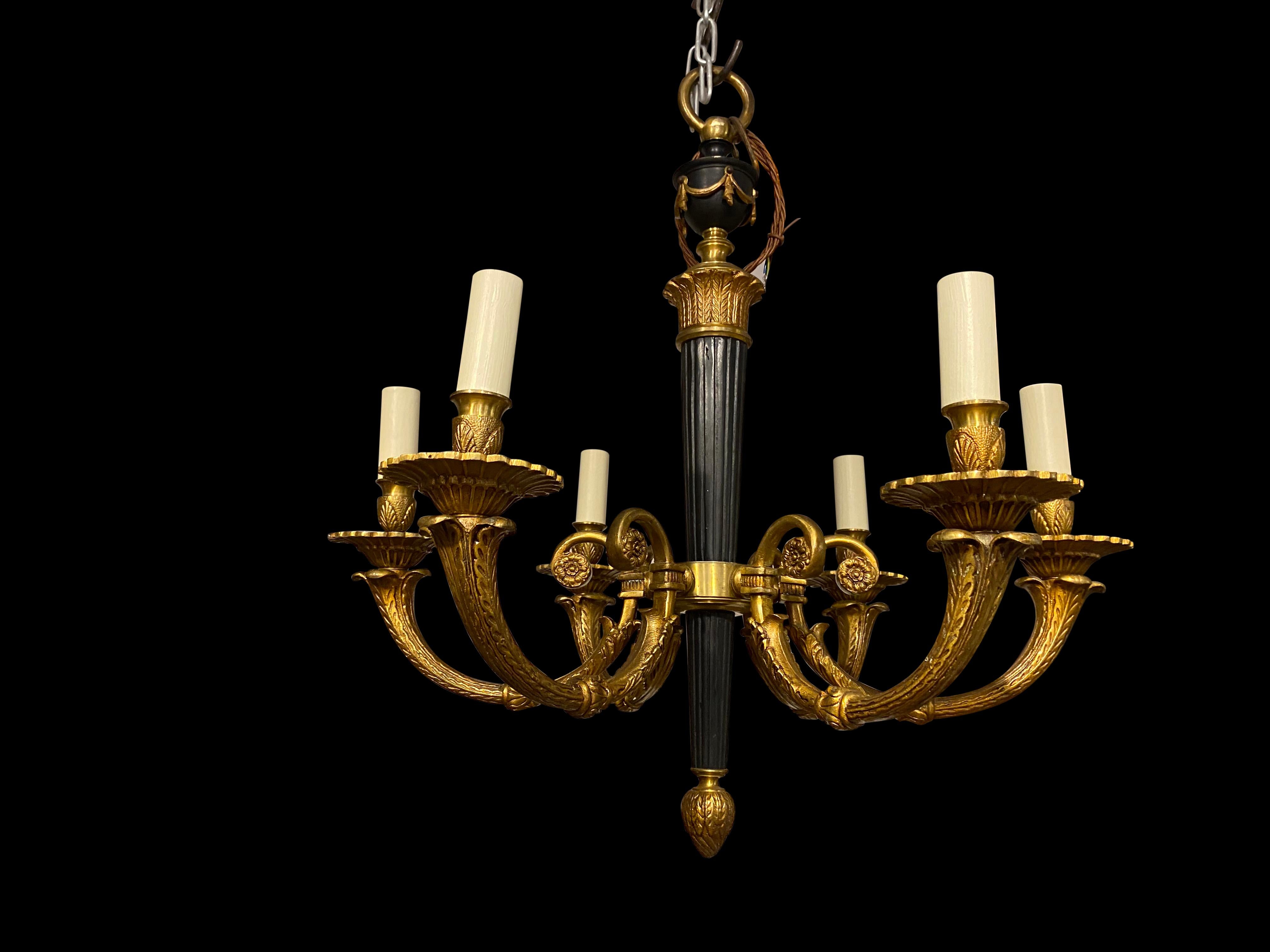 A 19th century French Empire chandelier, with central column and arrow sheath top cascading into an acorn finial. Surrounded by 6 elegant ormolu casted arms.