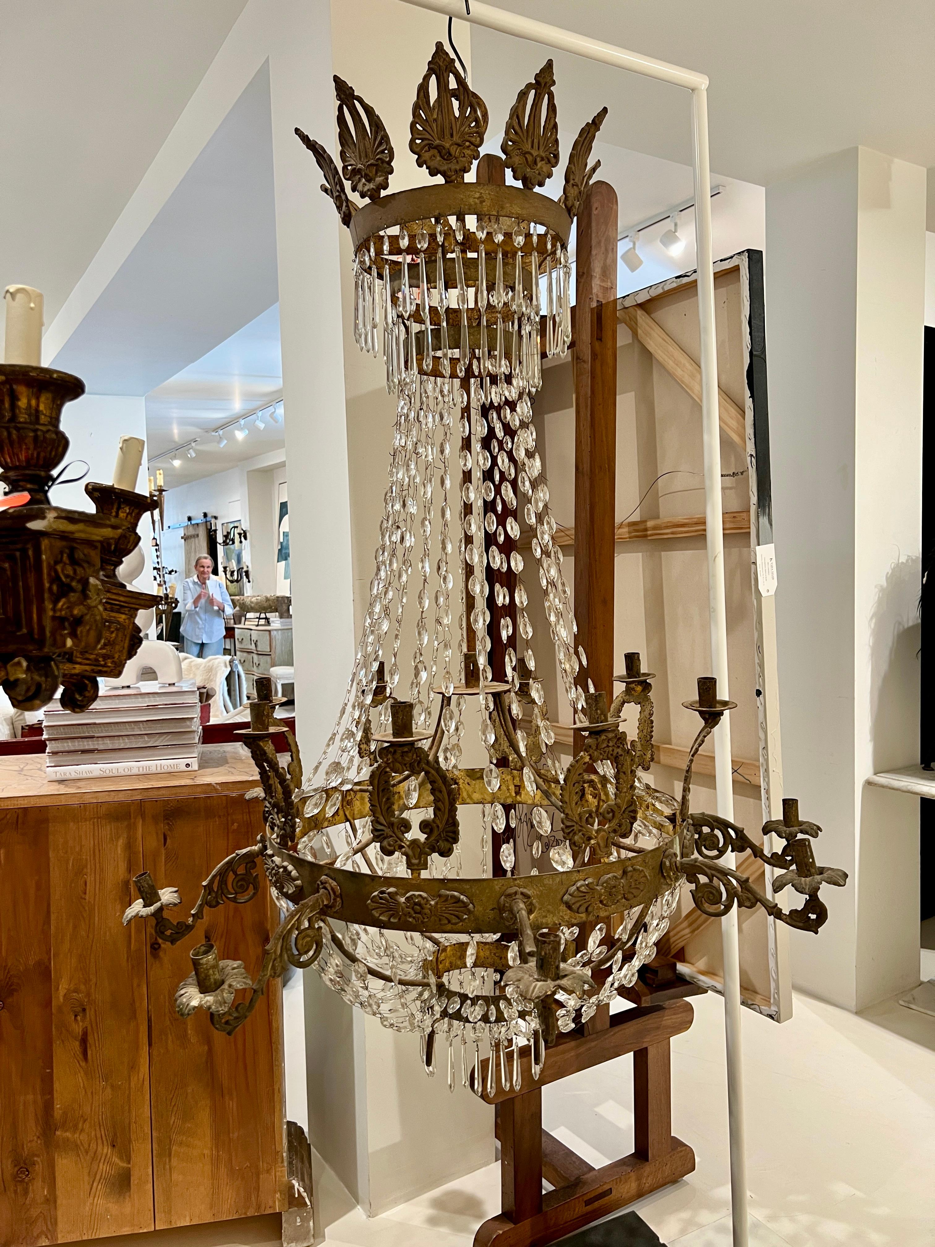 Un lampadario Eleg del XIX secolo, squisitamente realizzato con eleganza neoclassica. Questo grande apparecchio presenta una cornice in bronzo dorato ornata da motivi finemente dettagliati, tra cui foglie d'acanto, palmette e urne classiche. Sospesi
