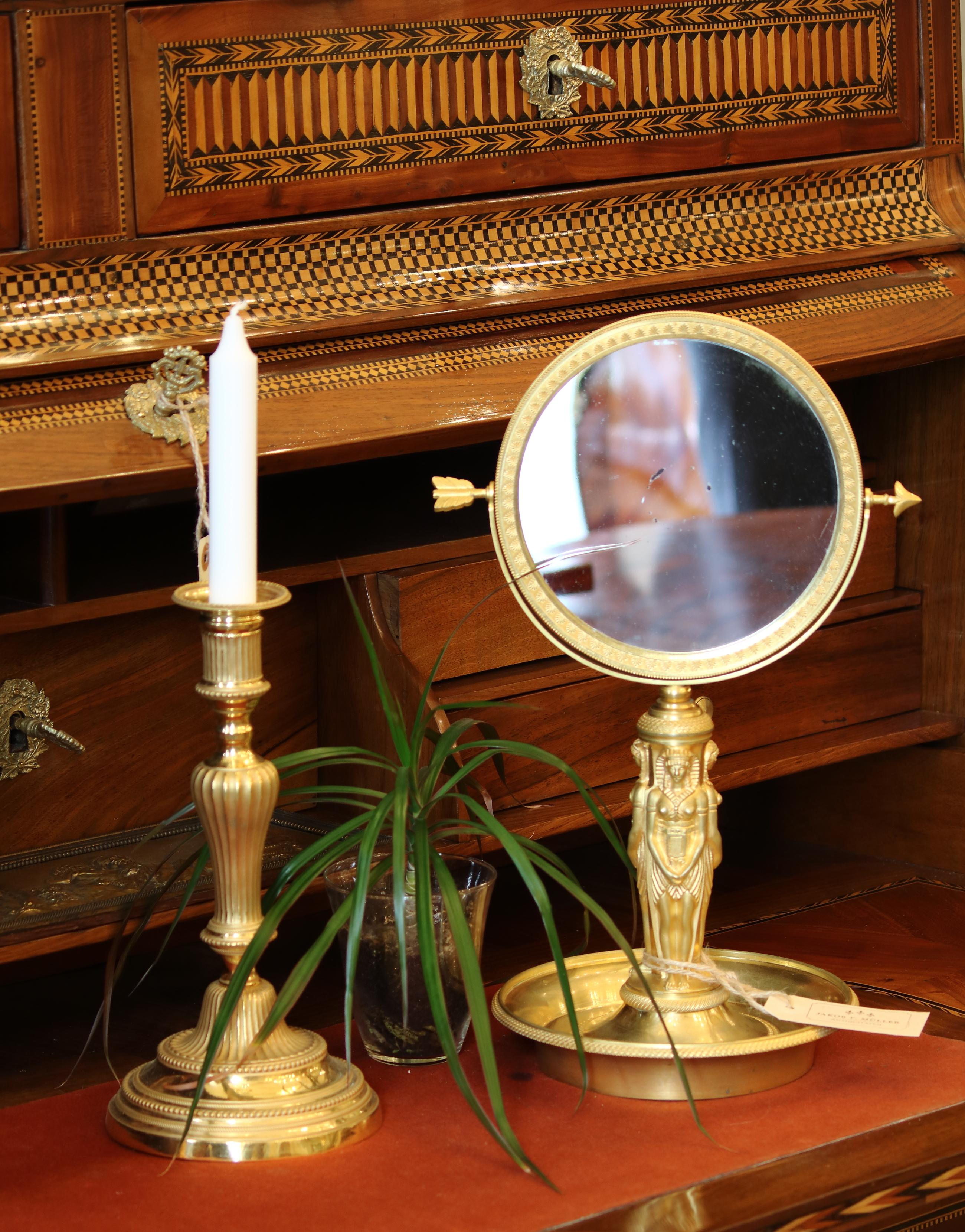 19th century French Empire Charles X Egyptian revival gilt bronze table mirror

A sculptural stem in the shape of three females in ancient Egyptian costume standing with their backs against each other issuing from a round dish-like base with a