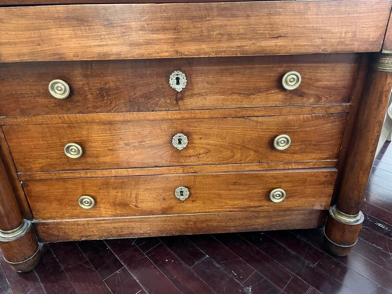 Una cassettiera Impero francese del XIX secolo in noce, con tiranti in ottone e accenti a colonna, mette in mostra un eccezionale artigianato d'epoca. Vanta quattro cassetti con incastri a coda di rondine e una bella patina che ne esalta il fascino