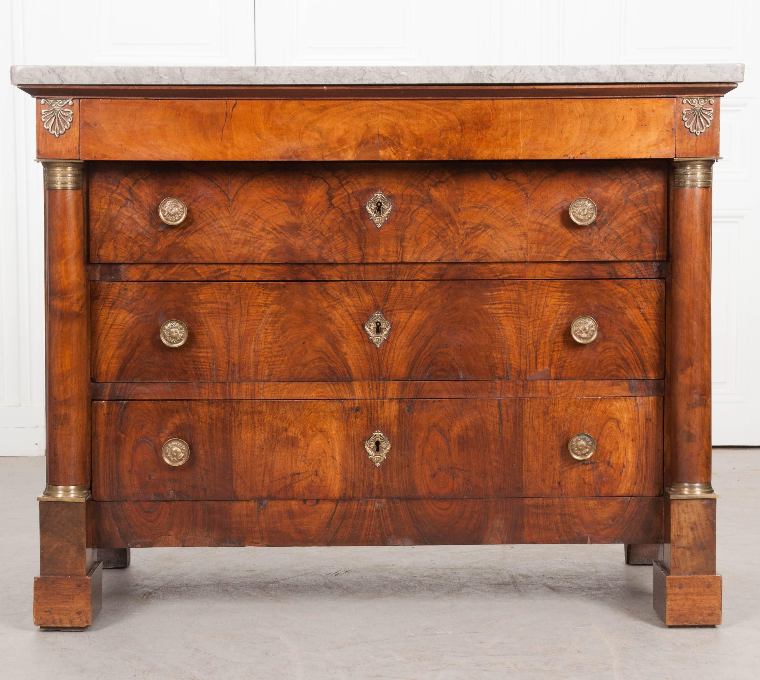 A stunning four-drawer Empire commode, made in France, circa 1860. A thick piece of gray marble rests atop the body. This marble is very well preserved and in wonderful antique condition. Just beneath the marble top is a hidden drawer, free of any
