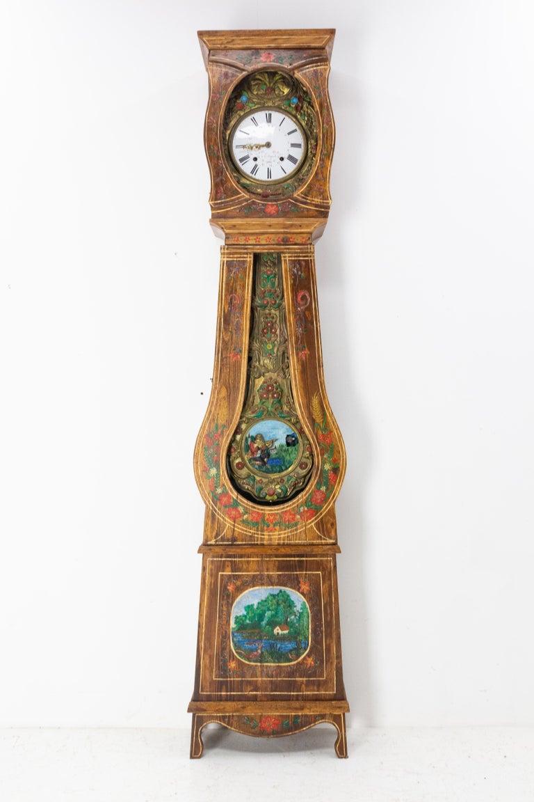 Grandfather clock or Comtoise from South West of France, Gers, late 19th century.
The pendulum and the clock are painted in Rococo style ornamentation.
On the pendulum a hunter in traditional dress aims is represented.
The case is ornate with a