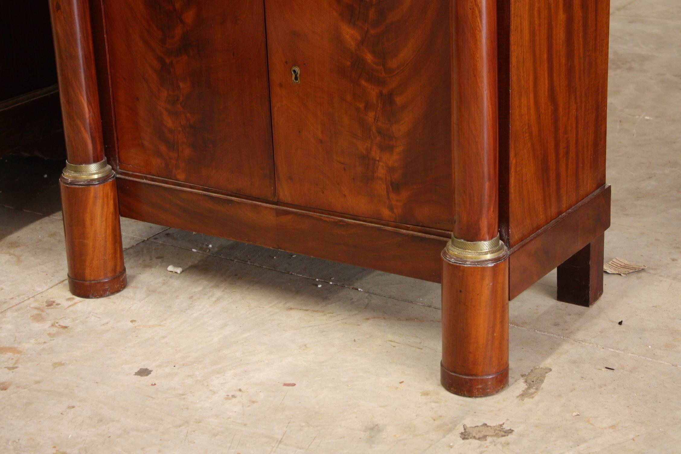 A 19th century French Empire drop front secretary. Has a marble top and side columns with bronze mounts, doors below with three drawers inside and one drawer above. The desk drops down to reveal a leather top writing surface and five additional