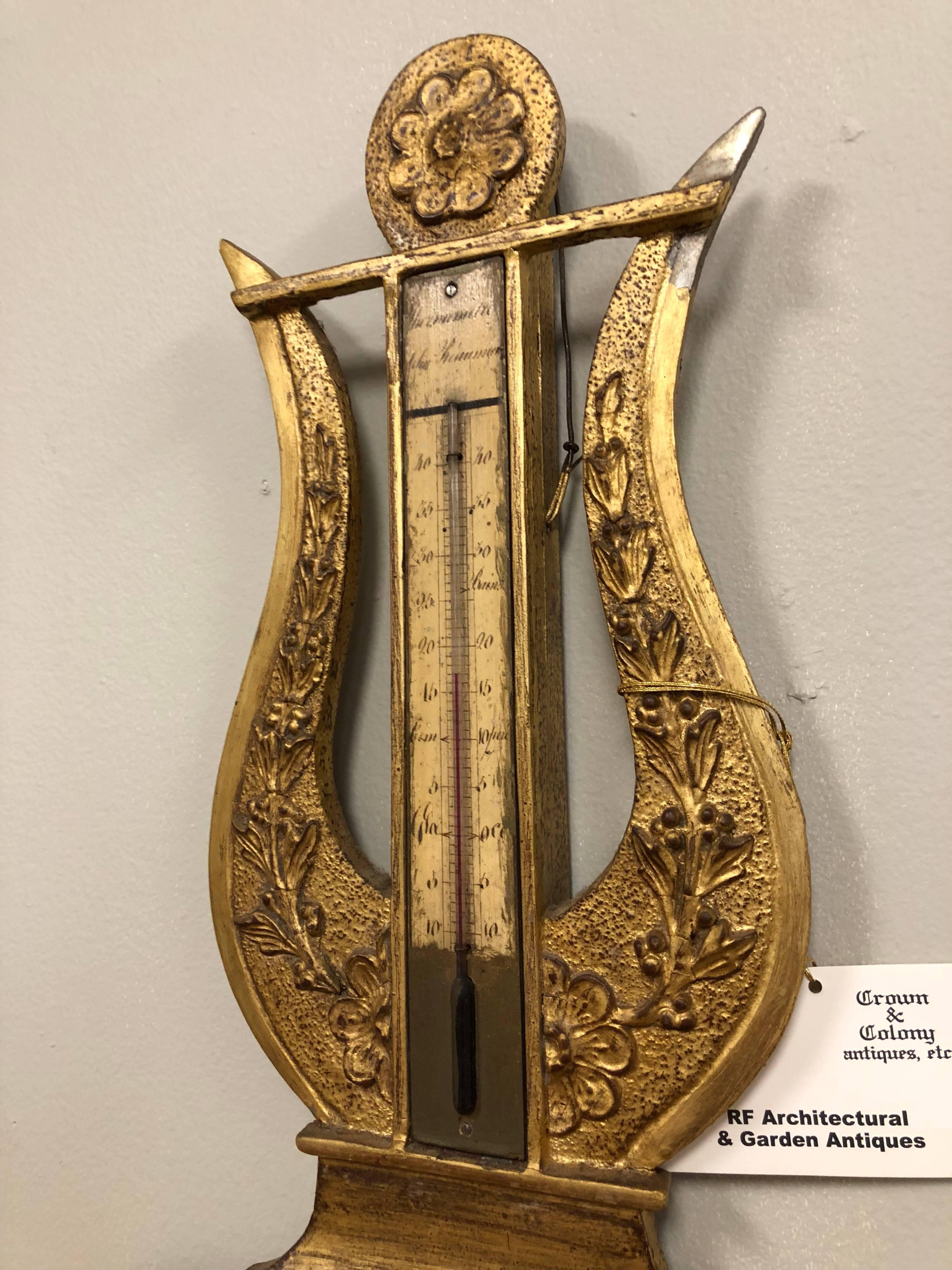 French Empire giltwood barometer or thermometer with lyre form over a octagonal shape.