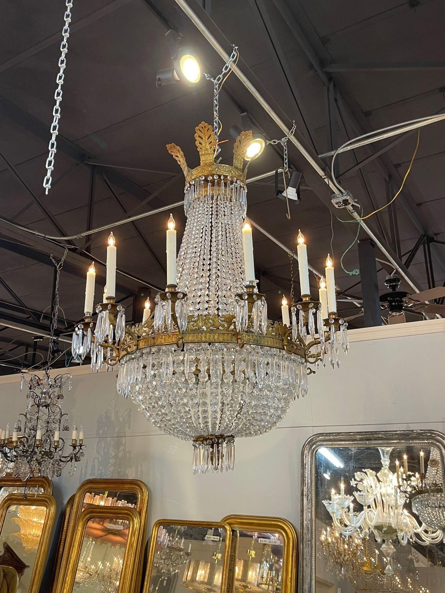 Exceptional 19th century French Empire gilt bronze and crystal basket form chandelier with 12 lights. Take notice of the very fine bronze details including decorative leaves and urns. And the shimmering crystals are gorgeous! An impressive piece!