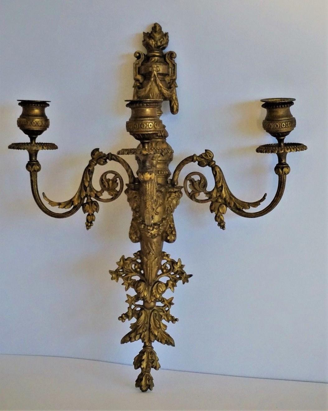 French Empire gilt bronze three-arm wall candleholder finely ornate with foliate, acorn motifs and three female faces, circa 1850-1870.
This wall candelabra can easily be converted to electric. In fine condition, wonderful aged