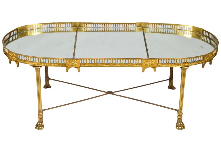 This early 19th century French gilt bronze plateau or 'surtout de table' features mirrored surfaces surrounded by an architecturally styled gallery of great ornamental detail. The plateau rests on a later neoclassical style bronze stand with paw