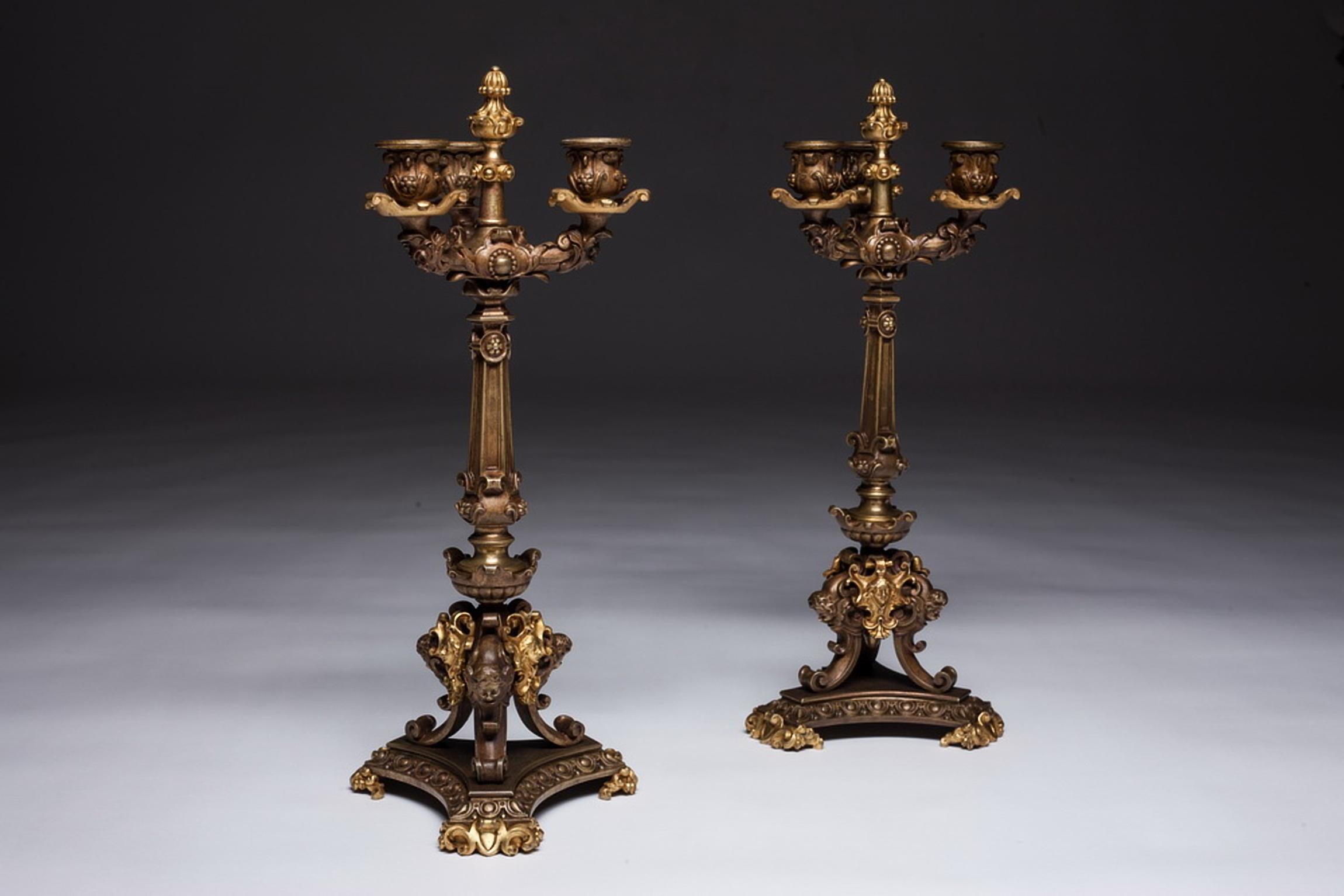 Magnificent pair gilt doré bronze three-light Empire style candelabras. Very well crafted and intricately detailed. Bottom is made with mythological figure faces. Columnar candelabra on triangular bases.

 