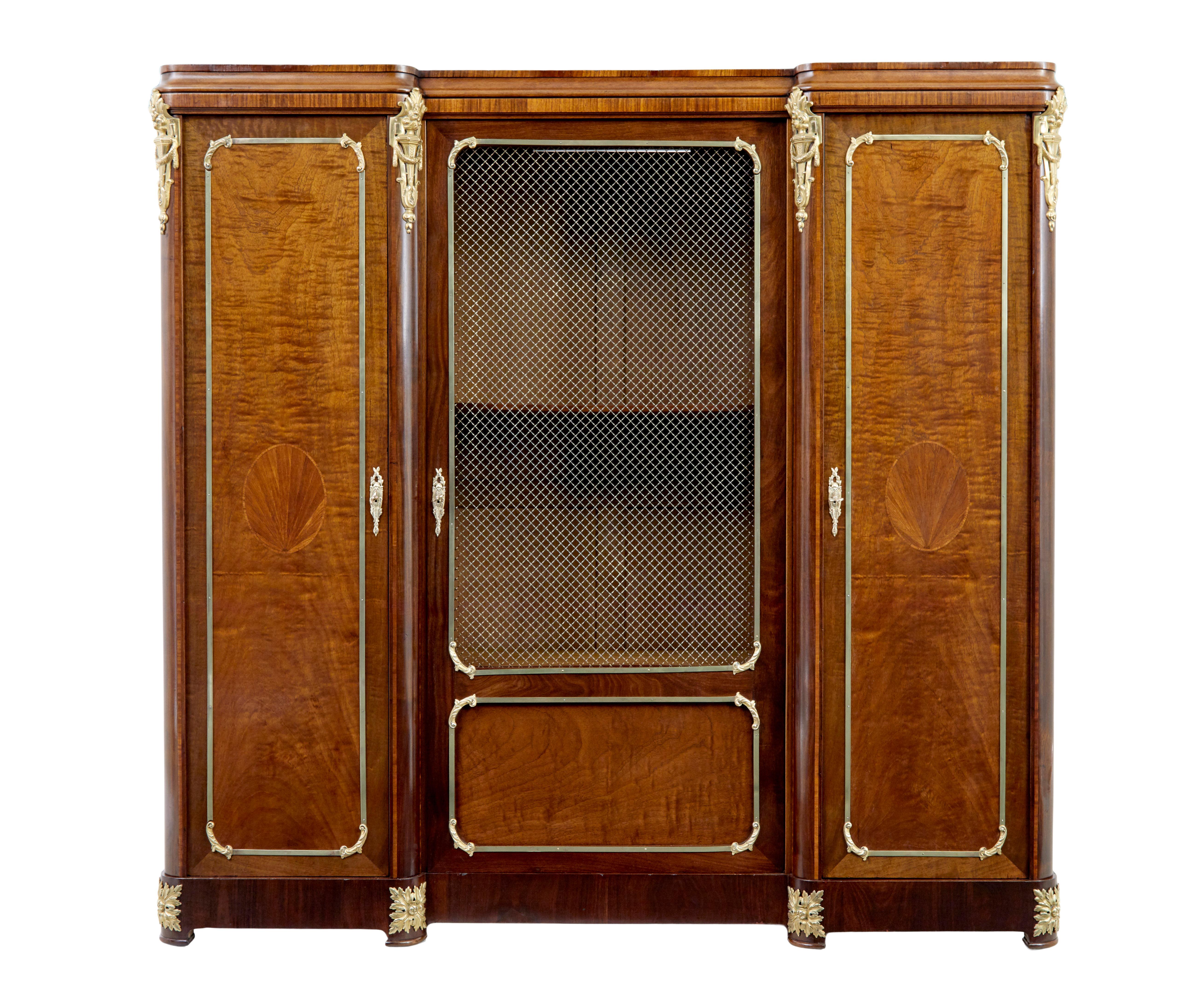 19th century French empire influenced mahogany cabinet circa 1890.

This cupboard was constructed using a flat pack technique, with panels held in place by bolts.

Central door with decorative latice wire design, flanked either side with a single
