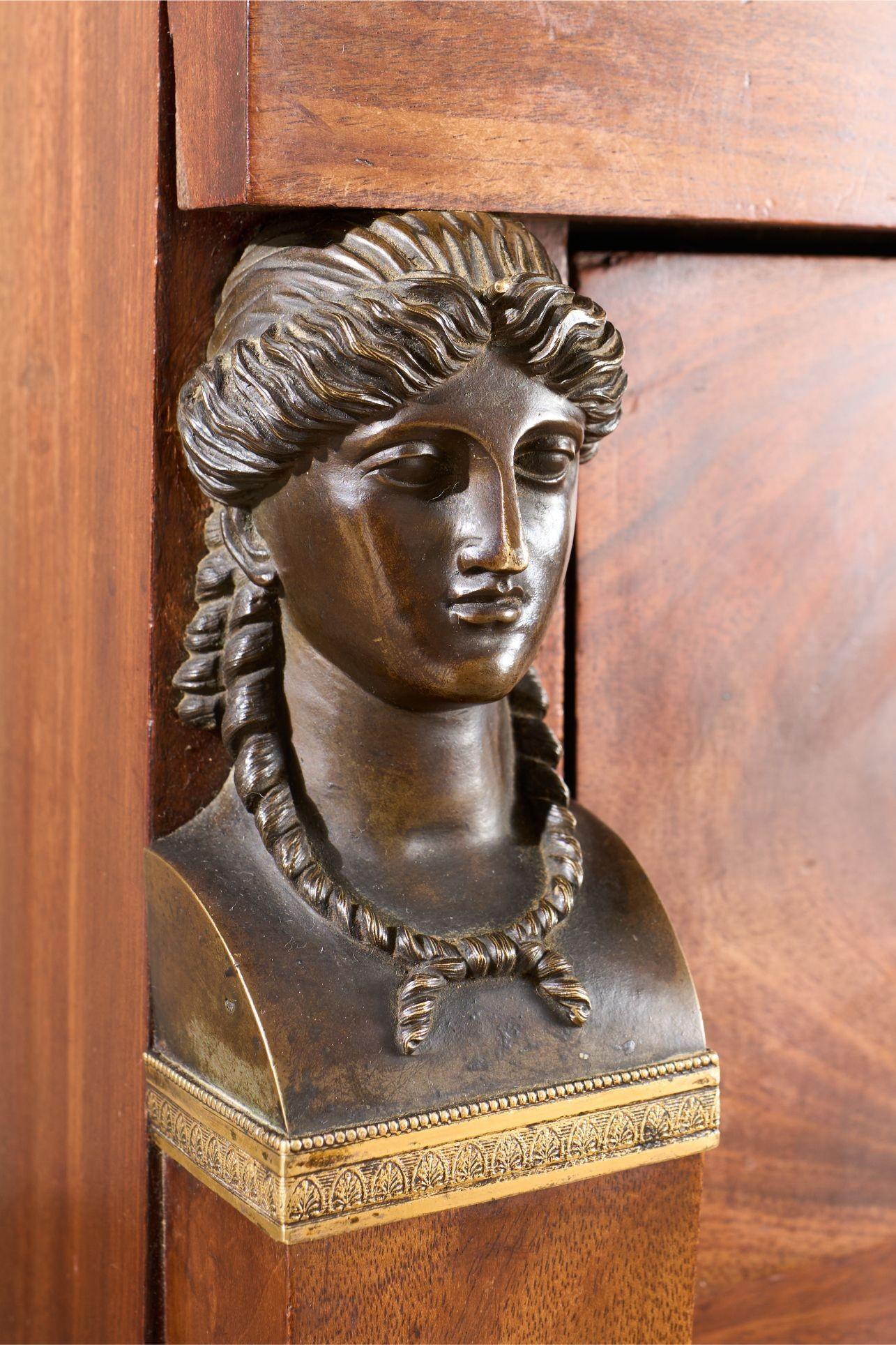 Il s'agit d'une commode empire française du XIXe siècle de très grande qualité. Fabriqué en acajou, il présente de superbes visages de déesses en bronze, un plateau en marbre fossile noir et des pieds originaux sculptés et peints. Tous ces éléments
