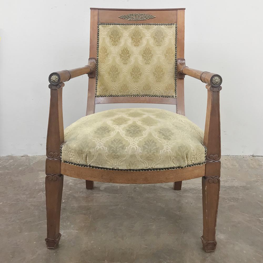 19th century French Empire mahogany armchair makes an ideal style statement for the tailored, more formal decor. Handcrafted from exotic imported mahogany embellished with cast bronze mounts, it boasts elegant comfort with timeless flair,

circa