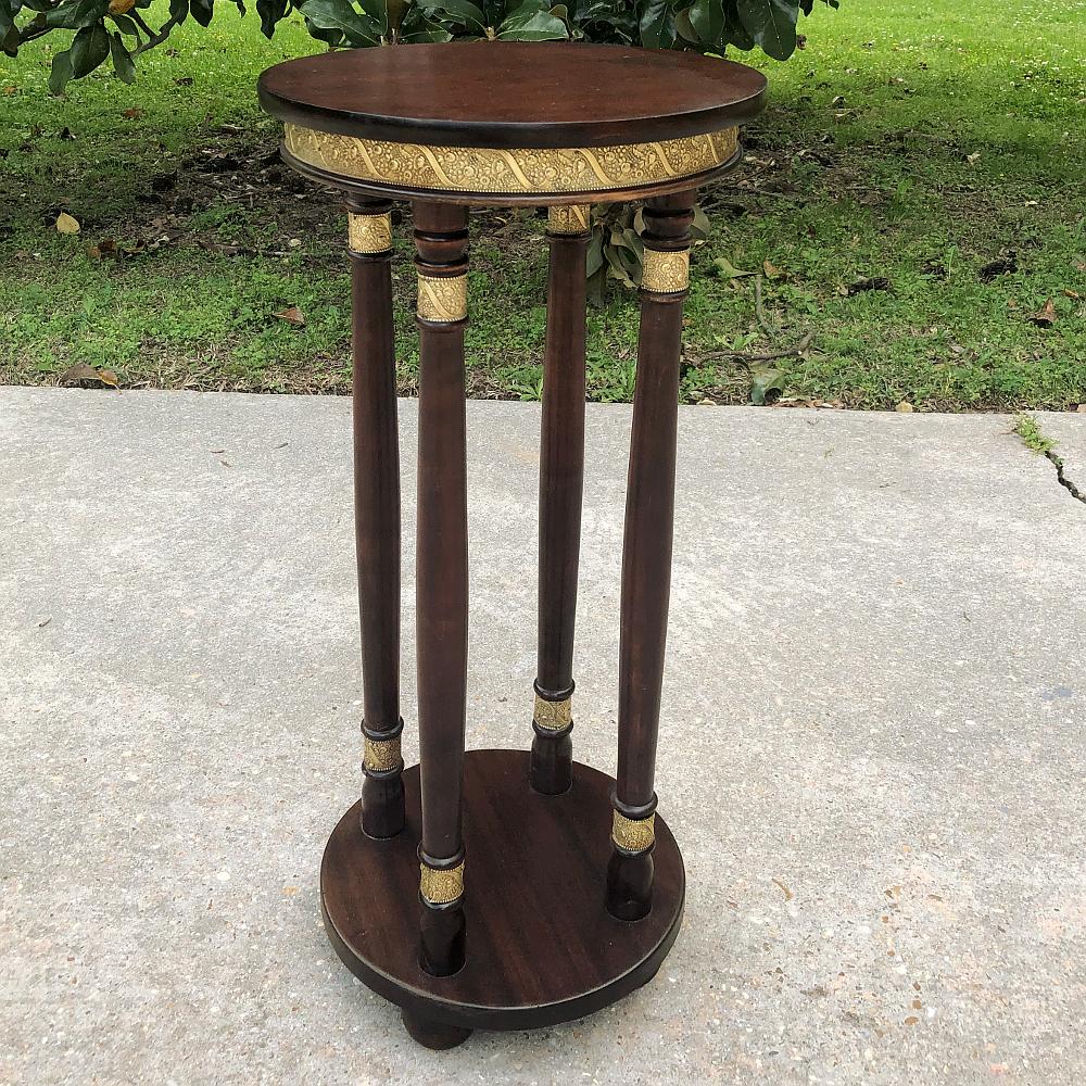 19th century French Empire Mahogany & Brass pedestal ~ end table was hand-crafted in France from exotic imported mahogany and lavished with embossed brass. The patterns appear around the apron, encircling the top of the columns, and also the base of