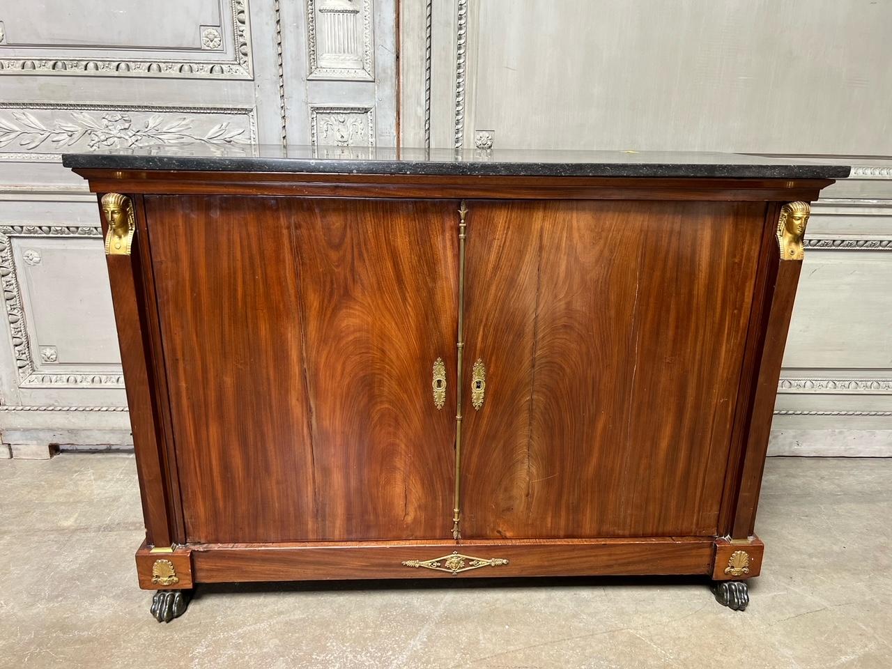 A period French Empire mahogany buffet with exceptional bronze mounts and an original stone top. This beautiful cabinet dates from the beginning of the 19th century and is very nice quality. There are some splits in the wood that can be filled, but