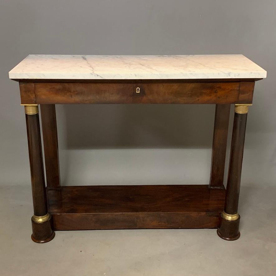 Lovely original French Empire period console table in mahogany with original brass mounts and marble top, circa 1840.
Great size, but being slim, it's quite an elegant piece of furniture.
Simple Classic style with the turned columns and full width